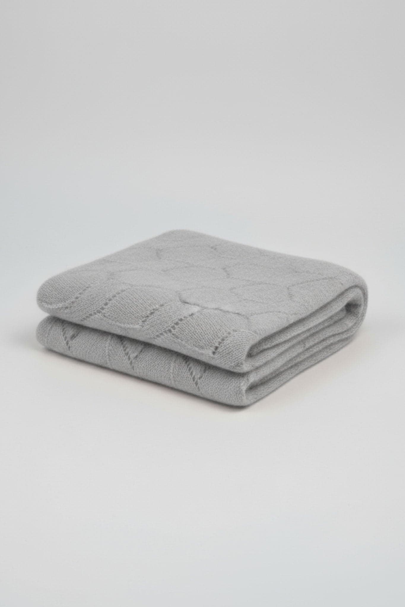 Detail of the gray cashmere scarf, highlighting the openwork texture for a refined touch in your looks...