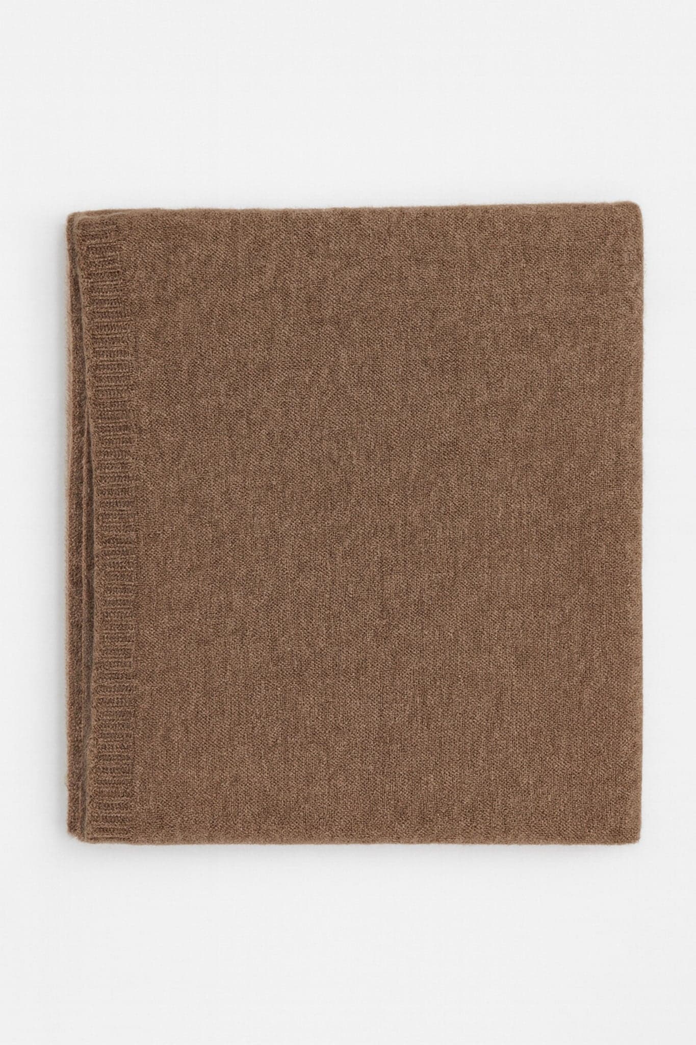 Primo piano della sciarpa marrone in cashmere, un accessorio elegante che evoca comfort e chic per il quotidiano