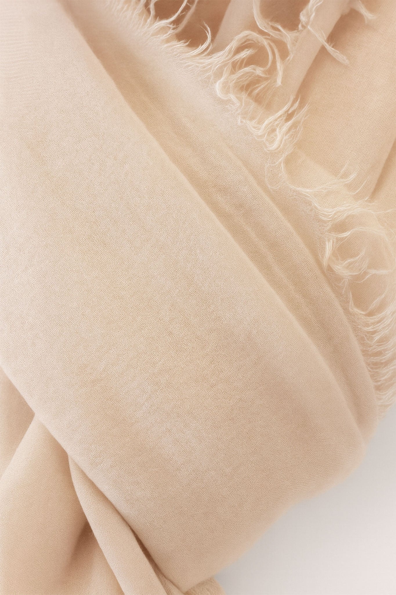 Delicate close-up of a blush pink scarf made from modal, wool, and cashmere, ideal for stylish layering in elegant occasions.