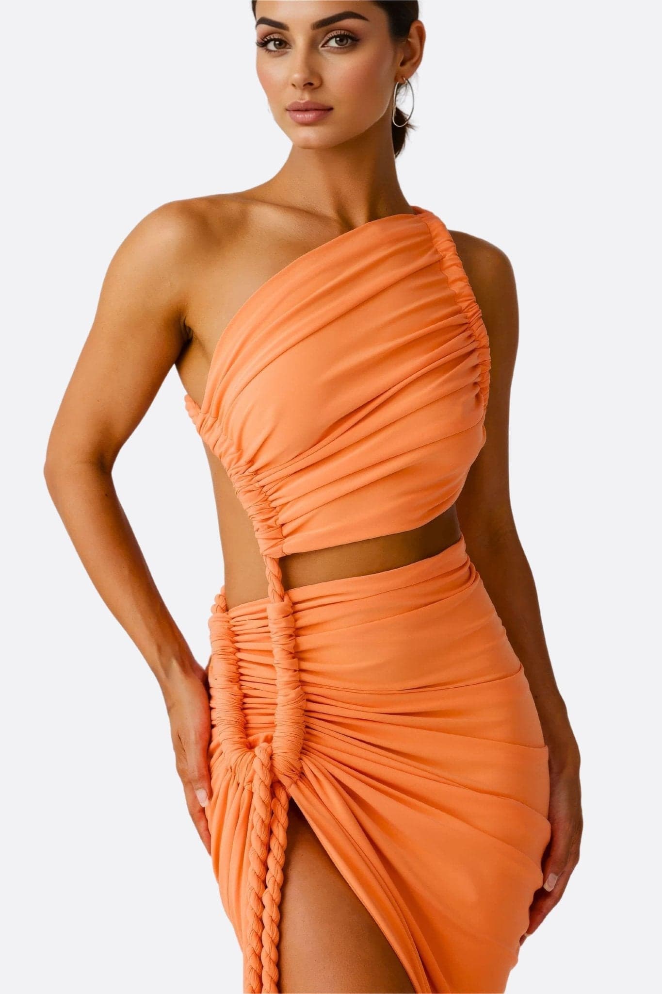 Close-up of the orange asymmetric drape of this chic beachwear set, perfect for elegant sunny evenings.