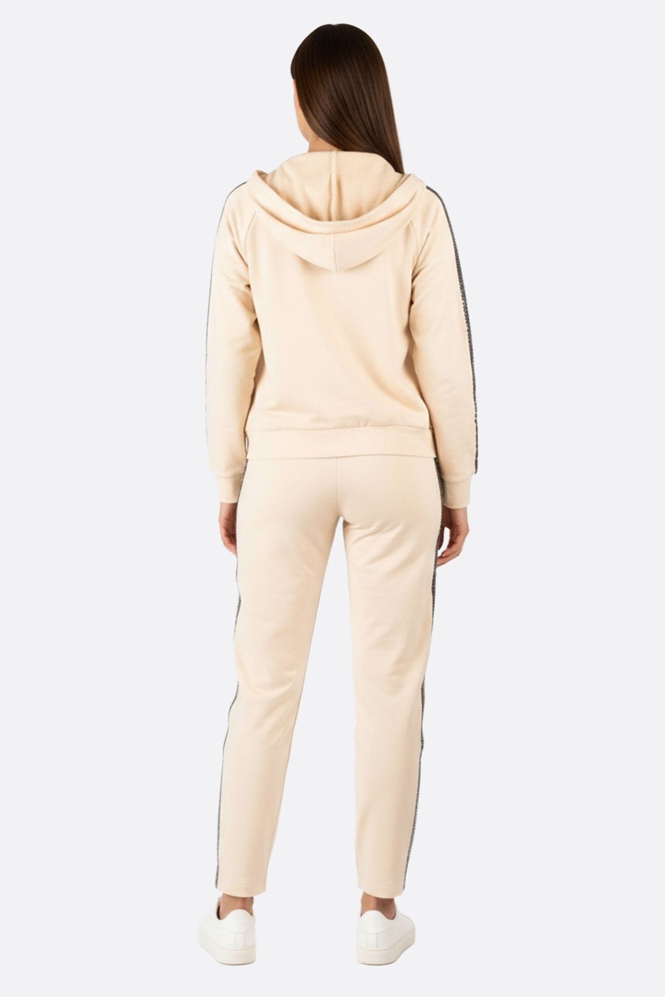Détail de l'ensemble de survêtement beige orné de bandes pailletées, idéal pour un look raffiné lors de sorties...