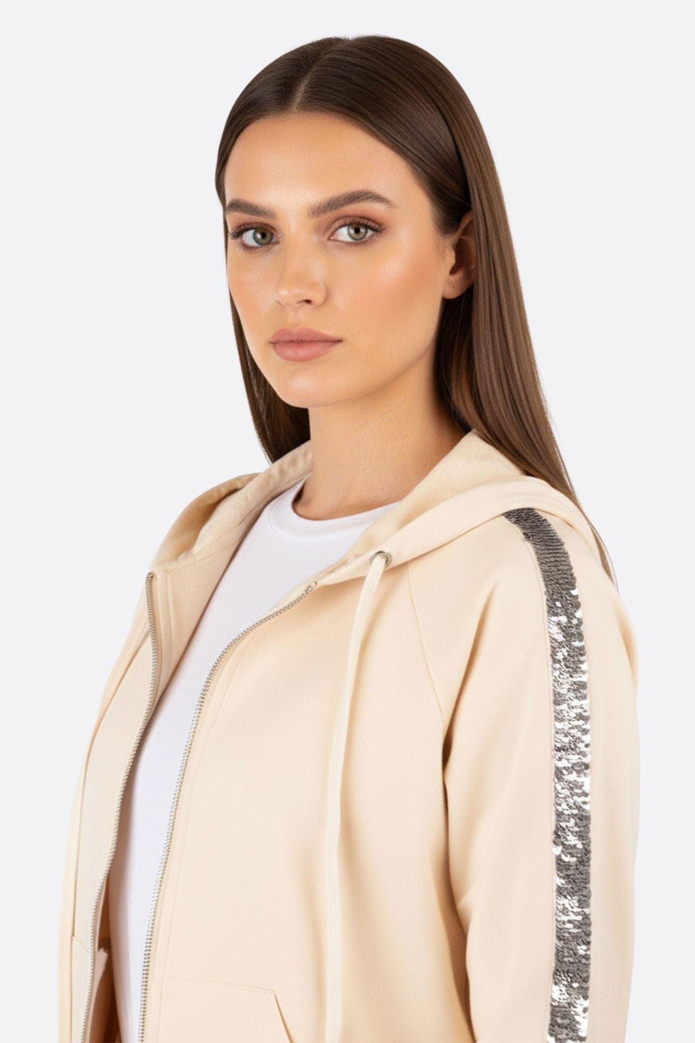 Détail des paillettes argentées sur l'ensemble de survêtement beige, un choix élégant pour une soirée stylée ou un brunch.