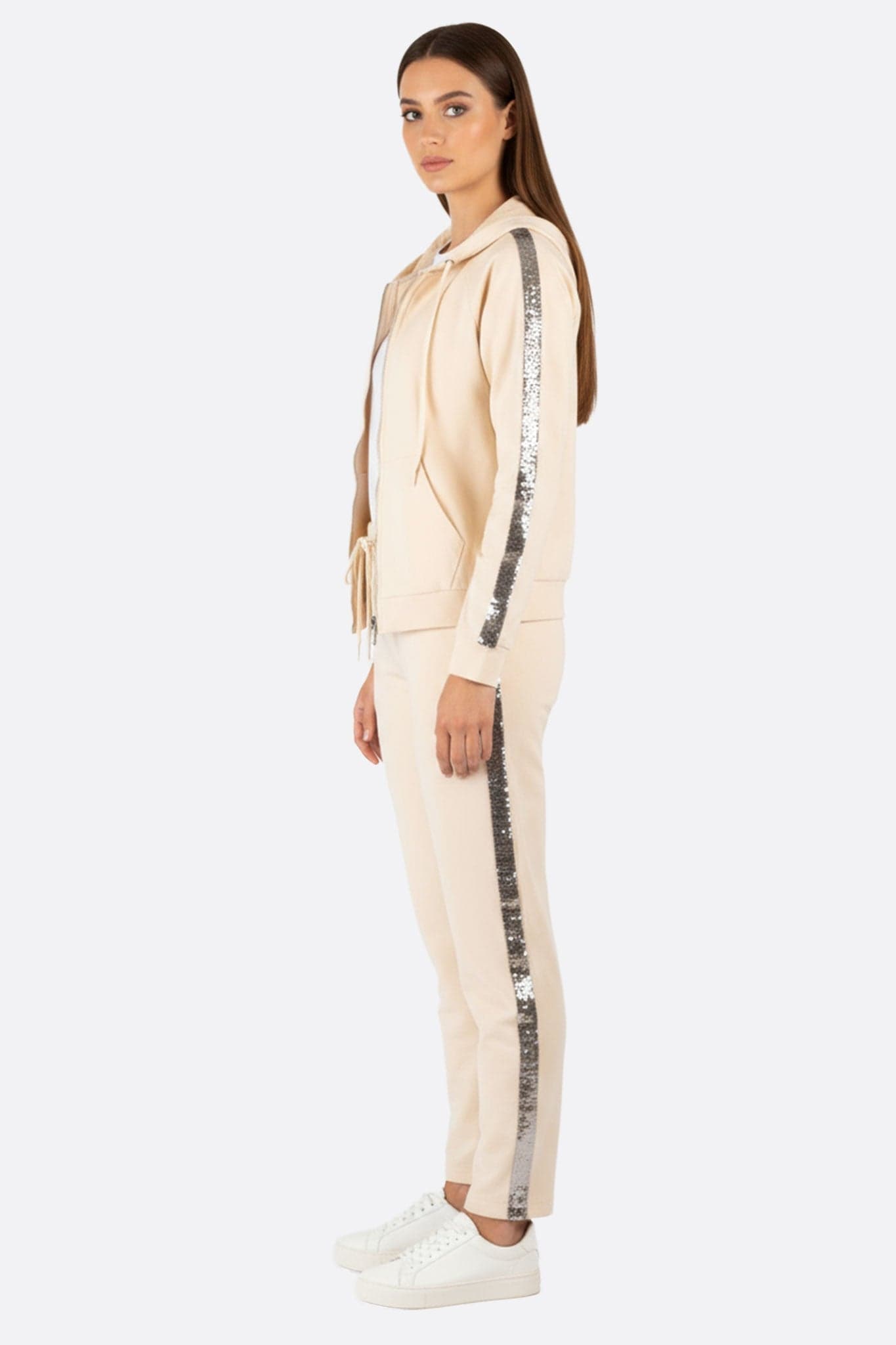 Zoom sur l'ensemble de jogging beige, décoré de sequins argentés, parfait pour des occasions élégantes et décontractées.