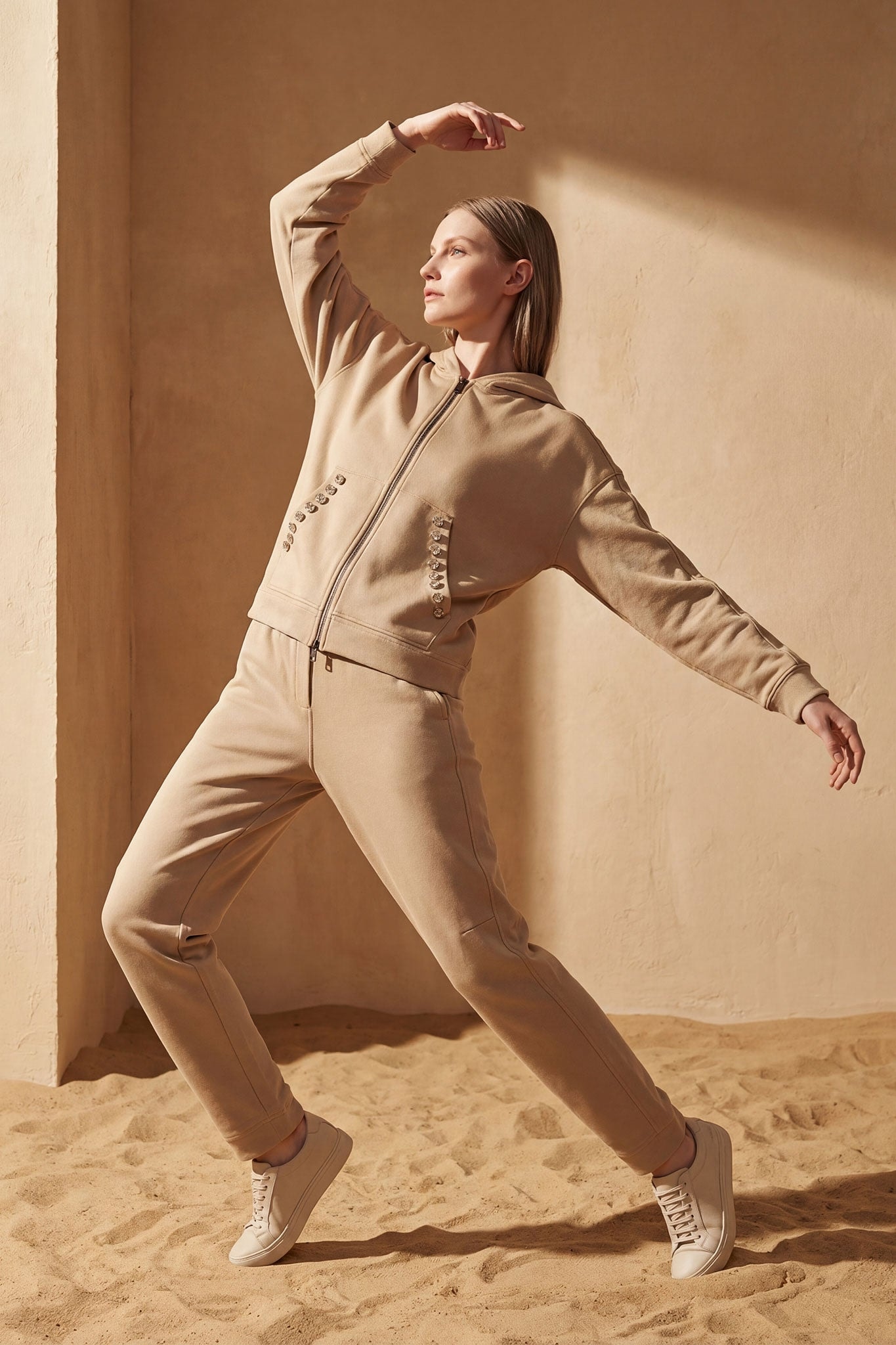 Soft texture of the beige tracksuit set, accented with faceted crystals for a chic and feminine allure