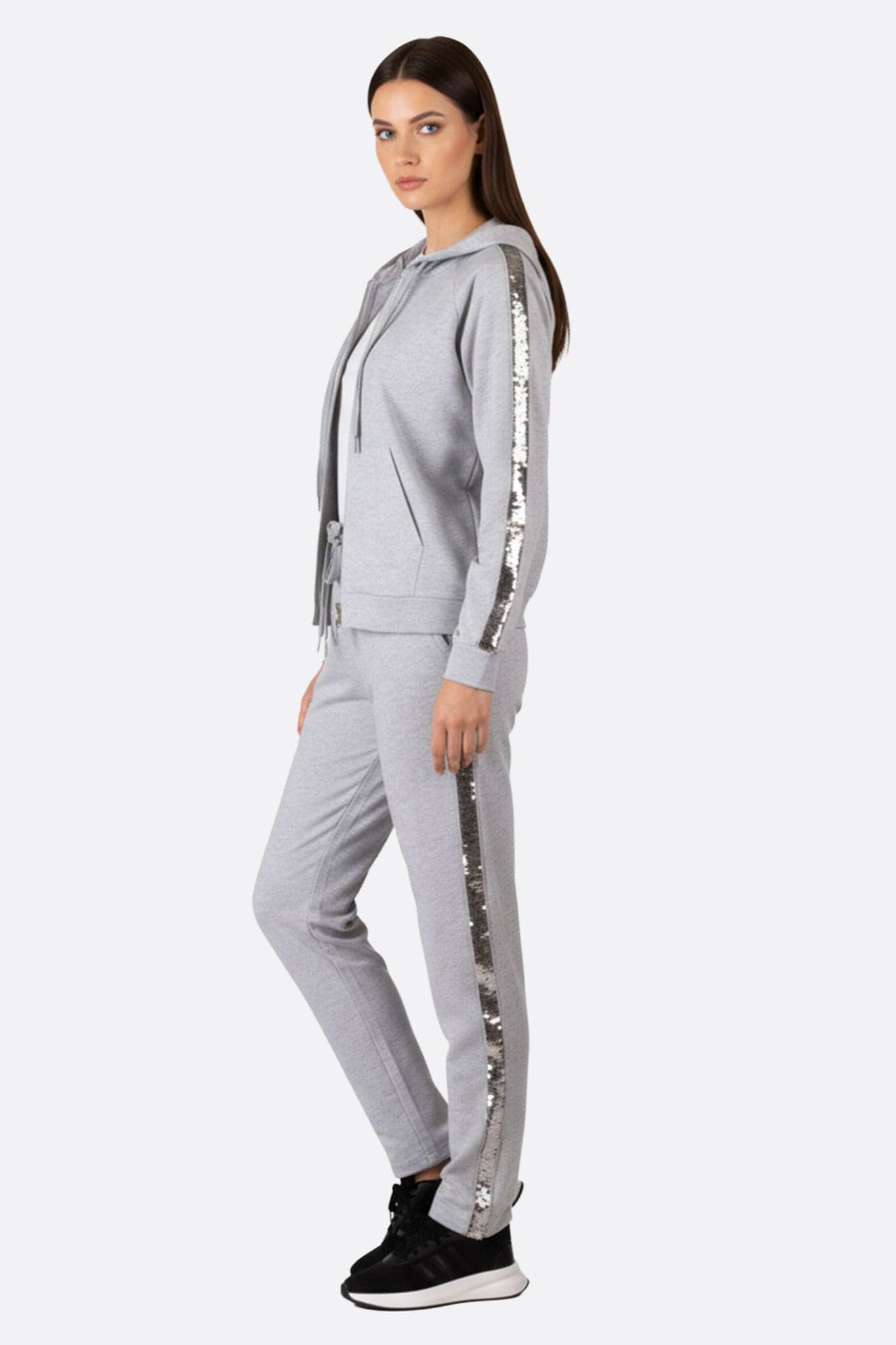 Close-up on the details of the pearl grey tracksuit, with shiny sequin stripes for a look...