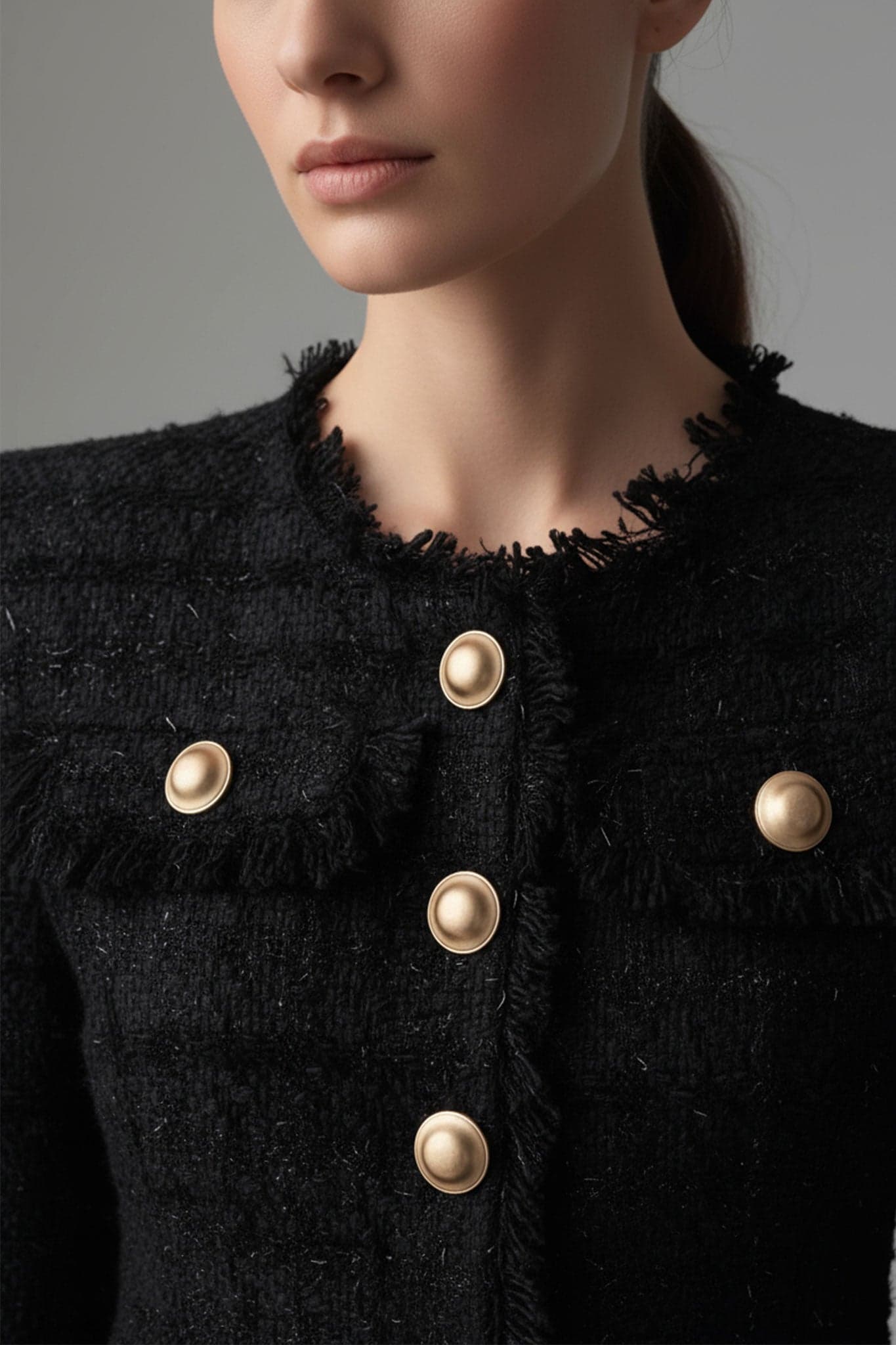 Detail des schwarzen Tweed-Revers am Damenblazer, das einen schicken Touch für Abendausflüge oder... hinzufügt