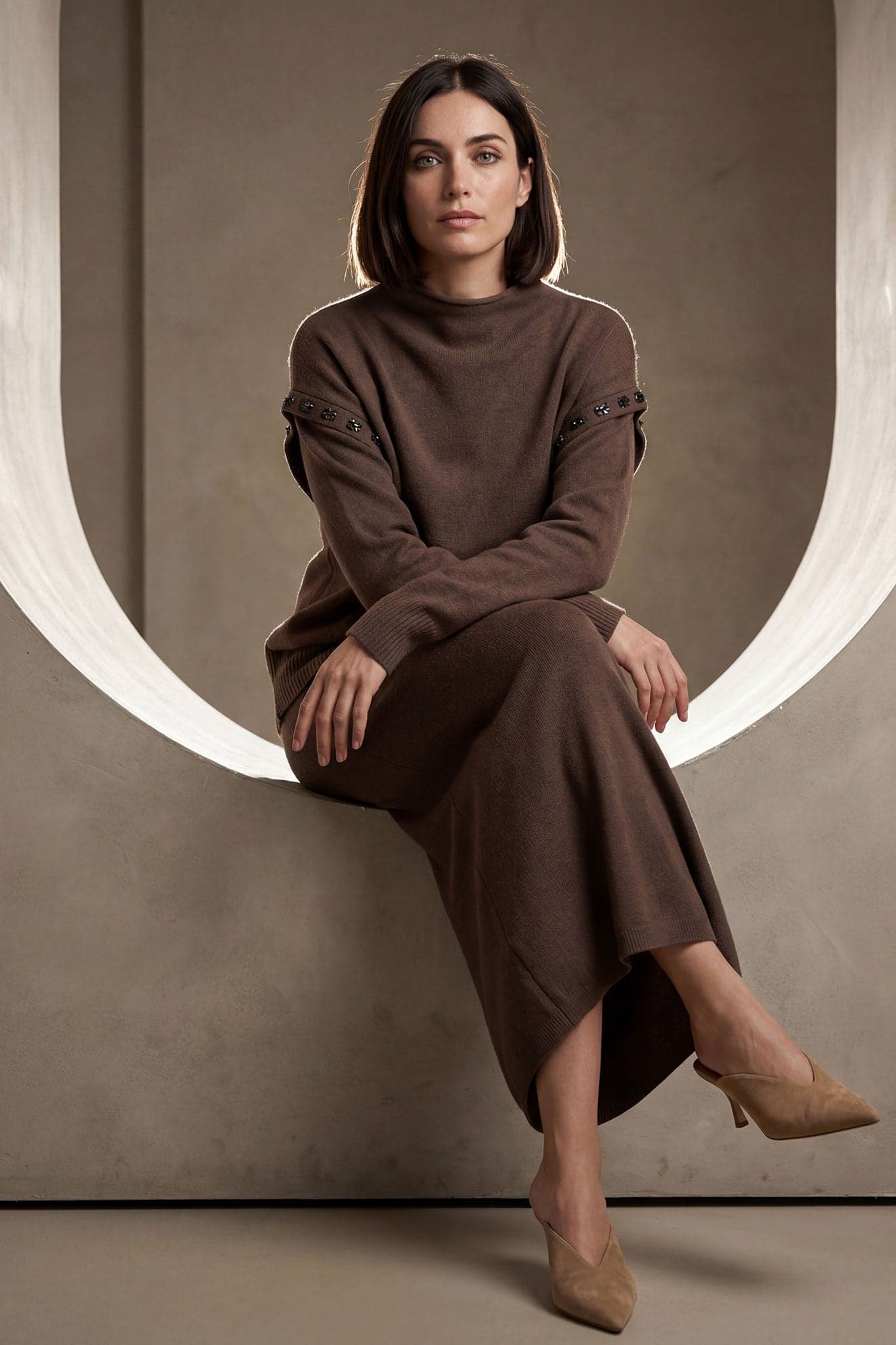 Texture douce et ornements délicats de l'ensemble jupe longue et pull marron, parfait pour une journée élégante d'automne.