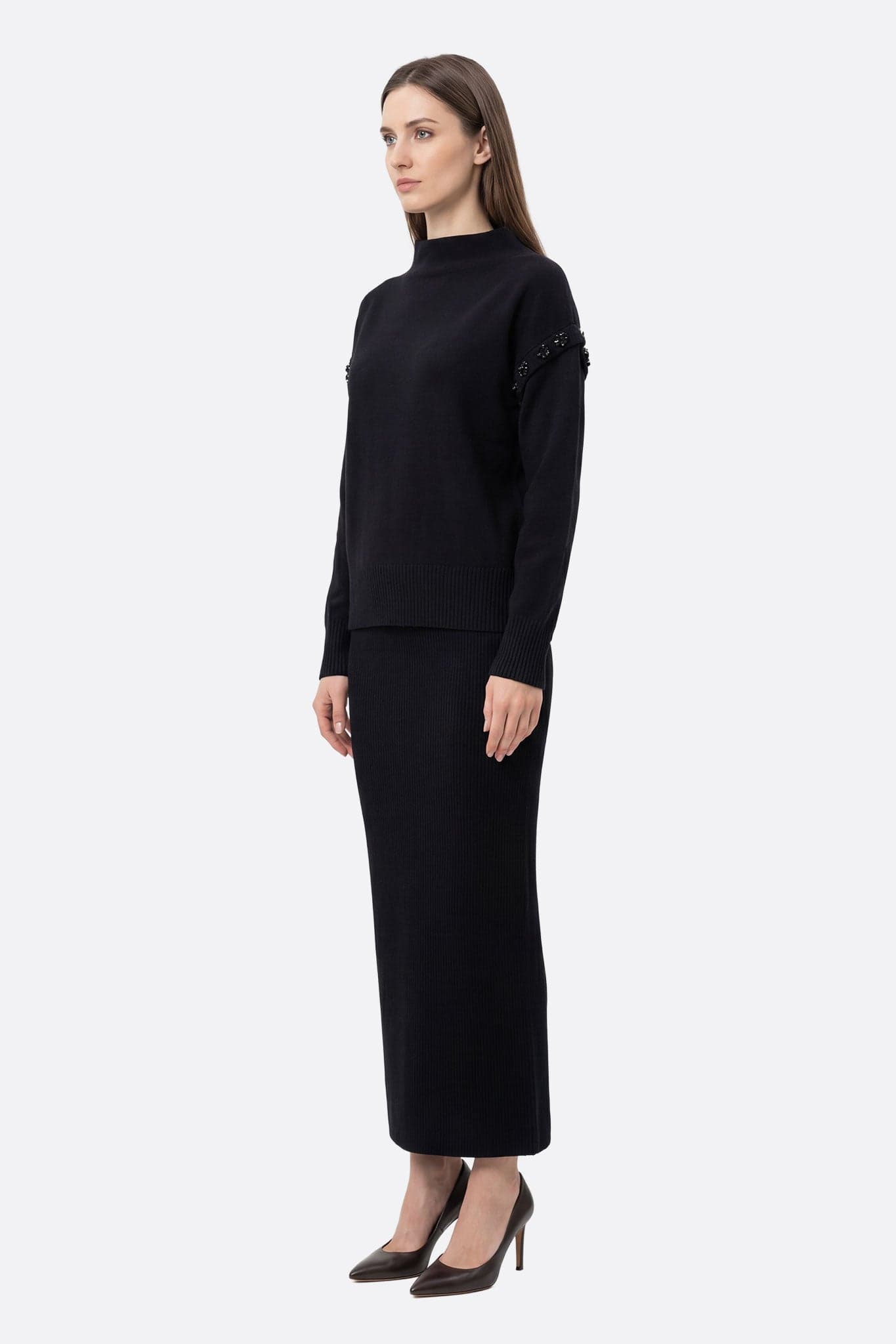Details of the black knit sweater and the elegant long skirt, an ideal ensemble for a chic and refined occasion.