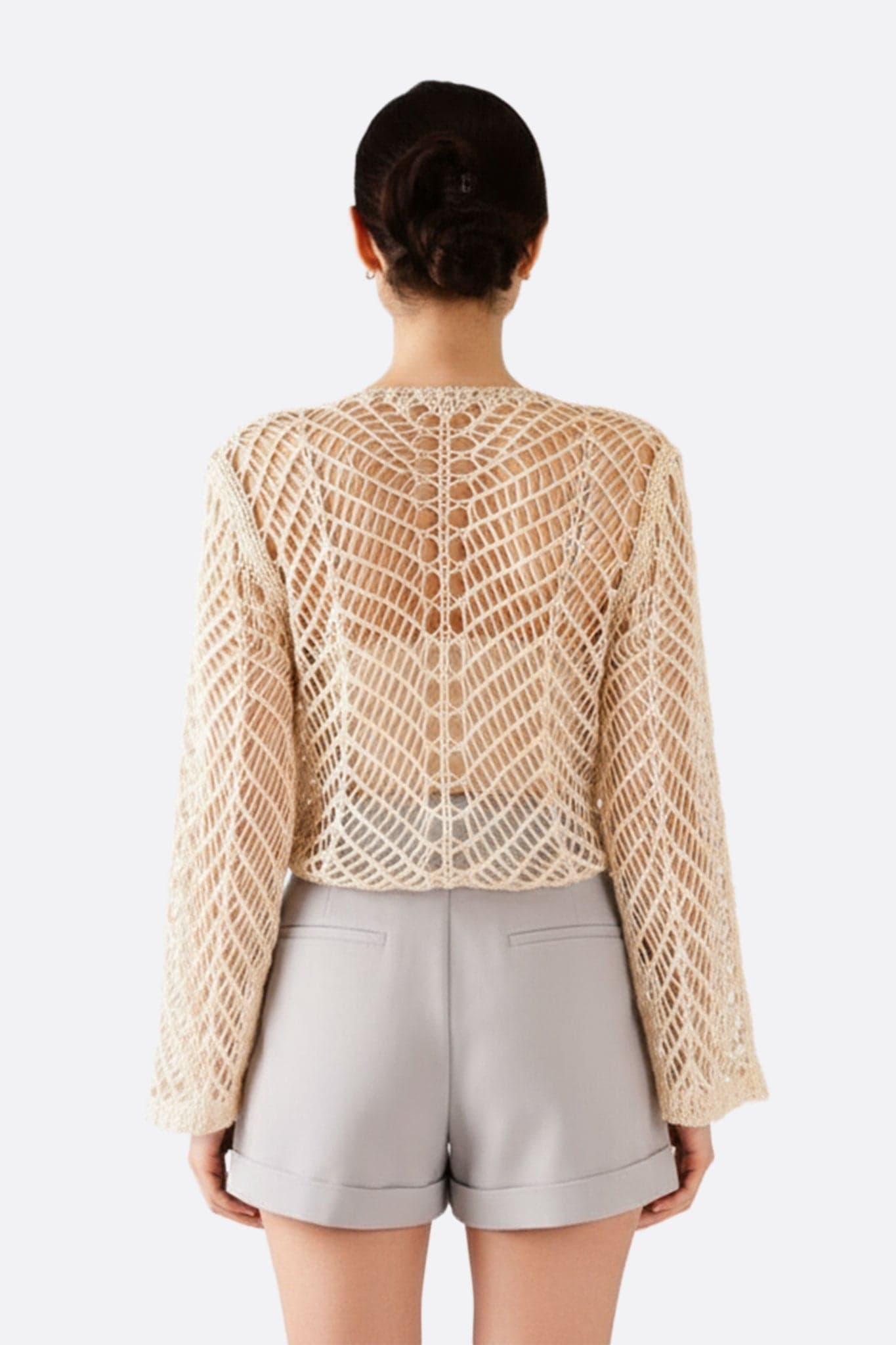 Alternatives Detail der beigen Häkelweste, leichte und Lochstruktur, für eine raffinierte und elegante Boho-Ausstrahlung.