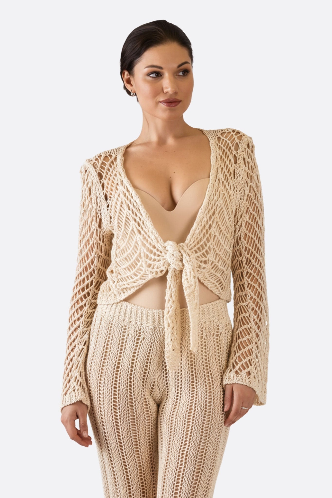 Gilet court beige en maille ajourée, tissage artisanal, style bohème chic pour un look moderne et élégant.