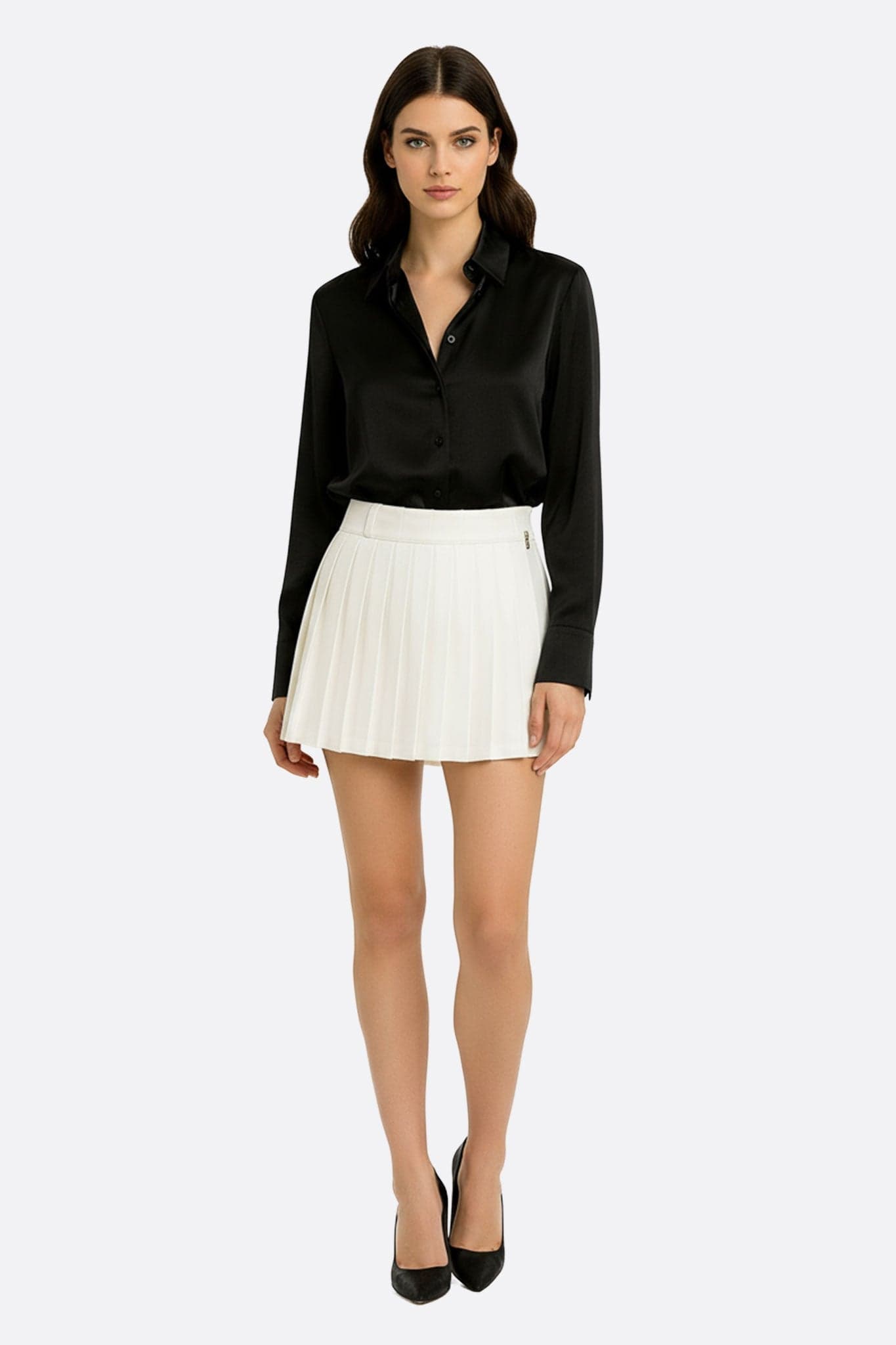 Gonna corta bianca dal drappeggio fluido, ornata da pieghe sofisticate, perfetta per un look chic da sera o da ufficio.