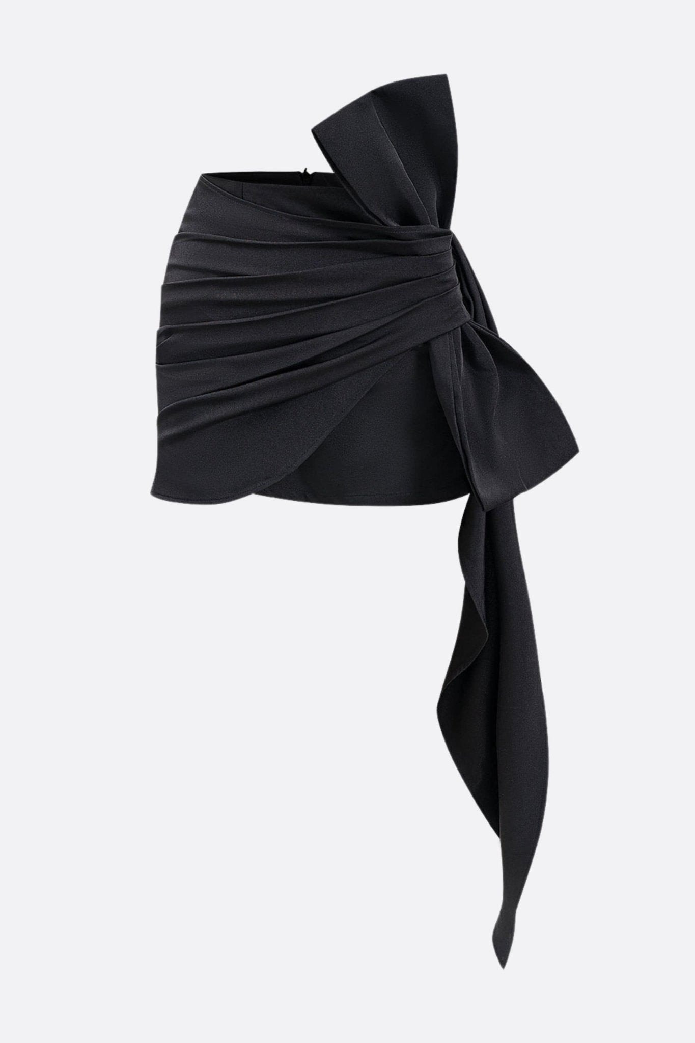 Vue alternative de la jupe noire drapée avec nœud oversize, soulignant son design asymétrique et son allure raffinée.