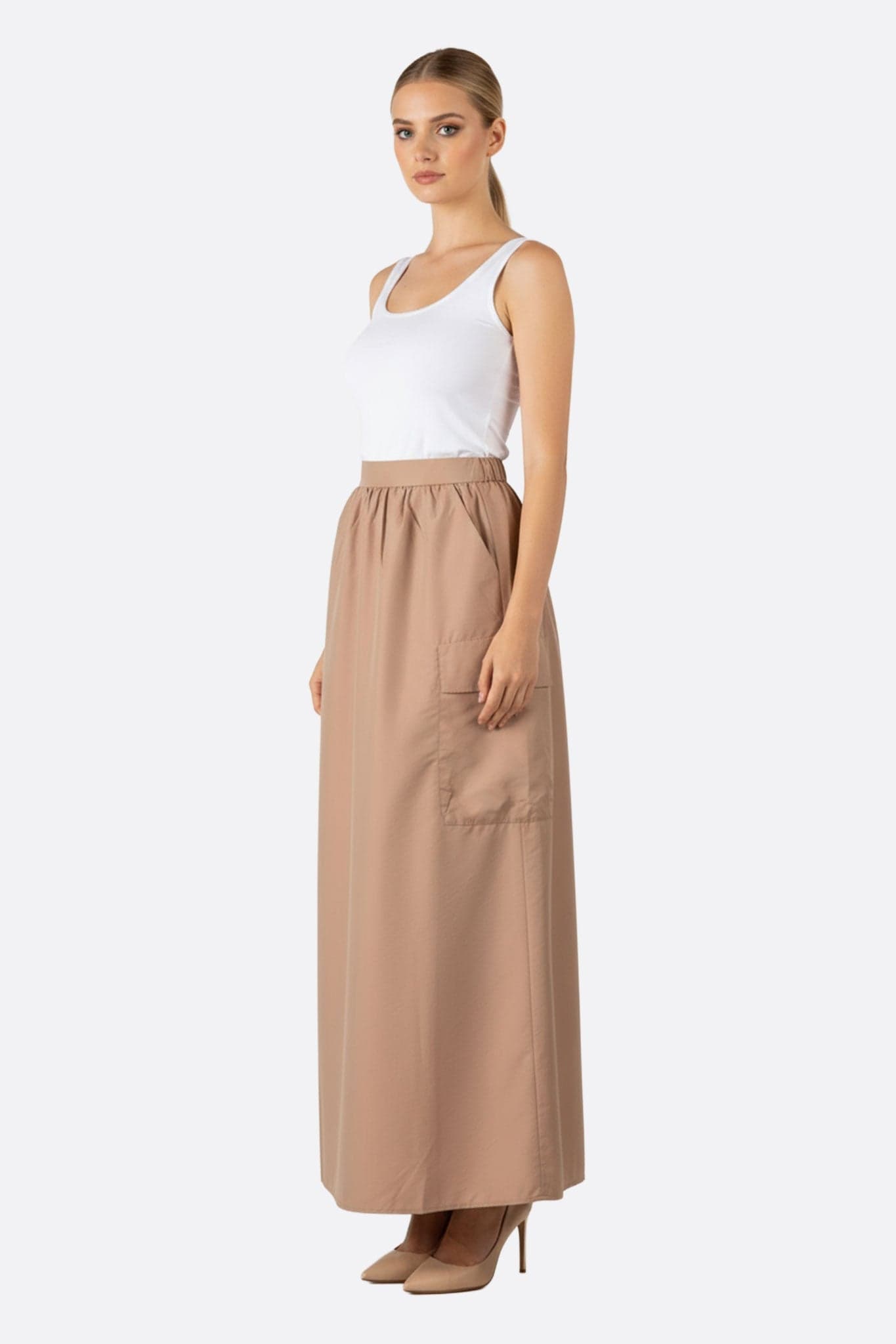 Dettaglio della gonna lunga color sabbia, con tasca applicata oversize, ideale per un look raffinato ogni giorno.