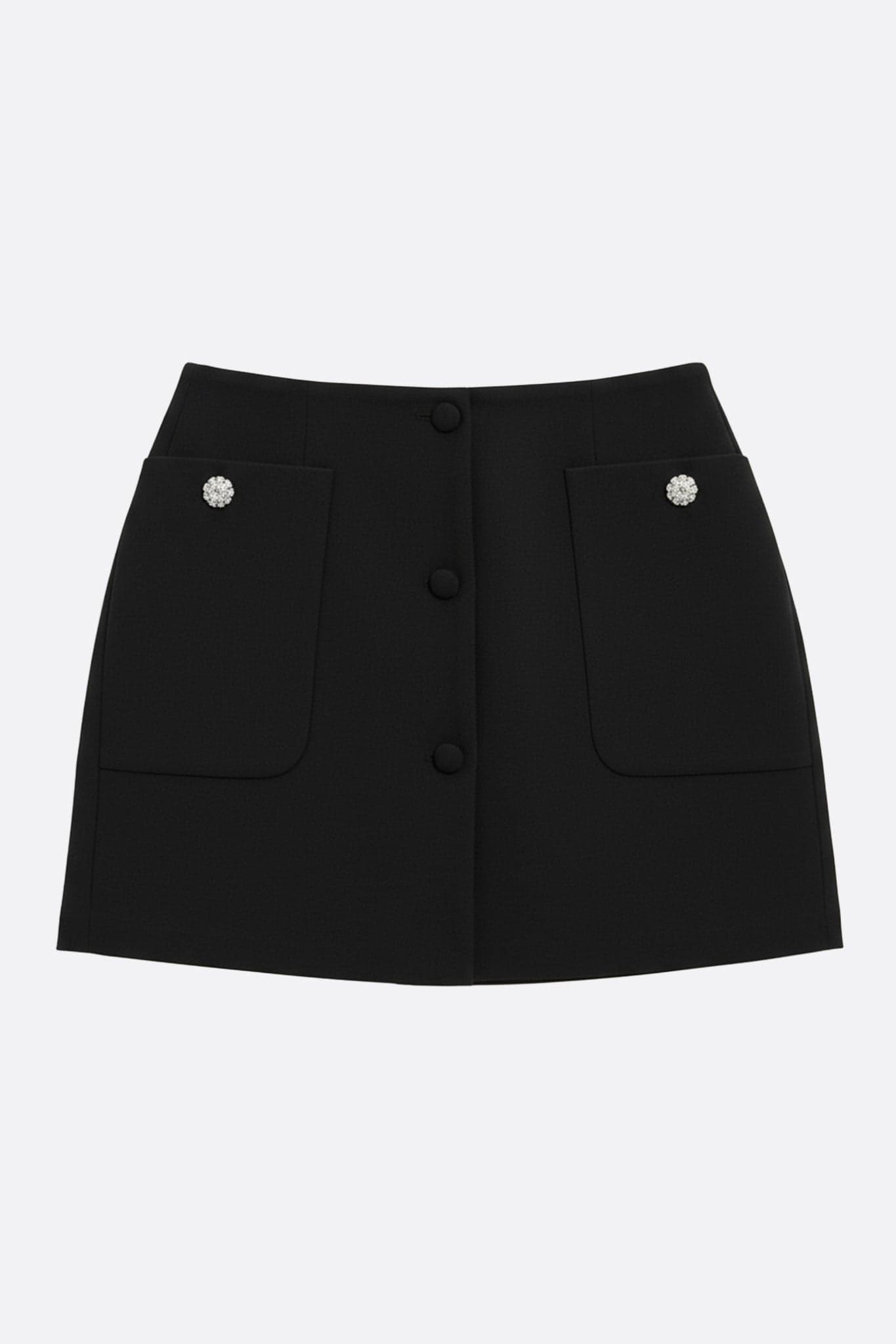 Gonna nera con tasche larghe e bottoni gioiello, vista tre quarti, che mette in evidenza il taglio dritto e l'eleganza per tutte...