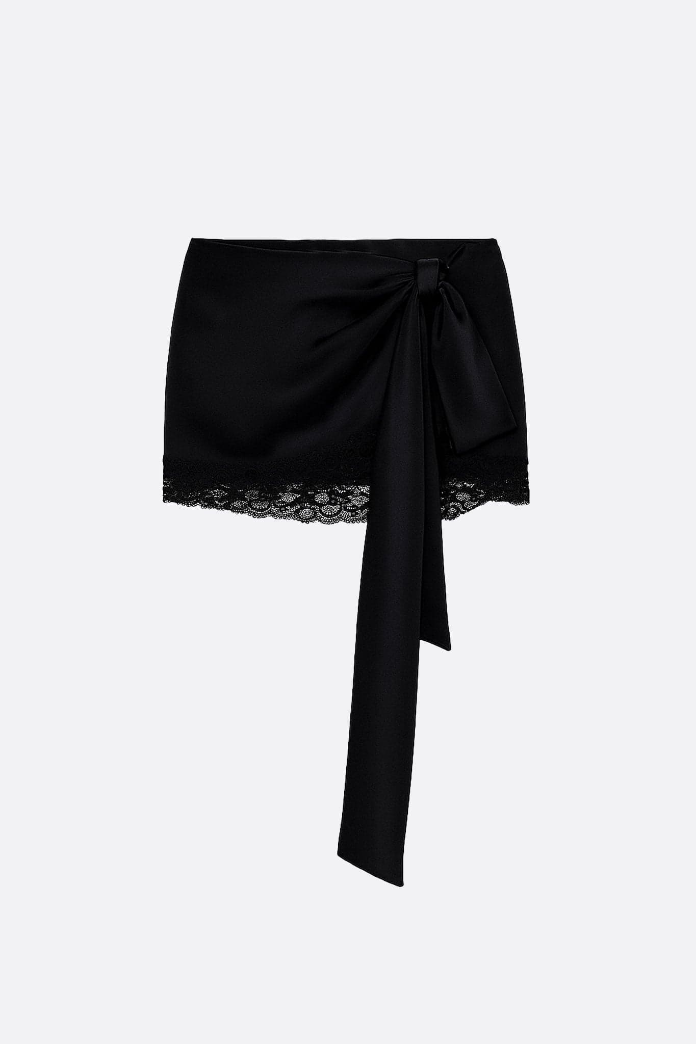 Dessous de jupe noire en satin et dentelle, mettant en avant l'asymétrie et la texture opulente pour un style chic.