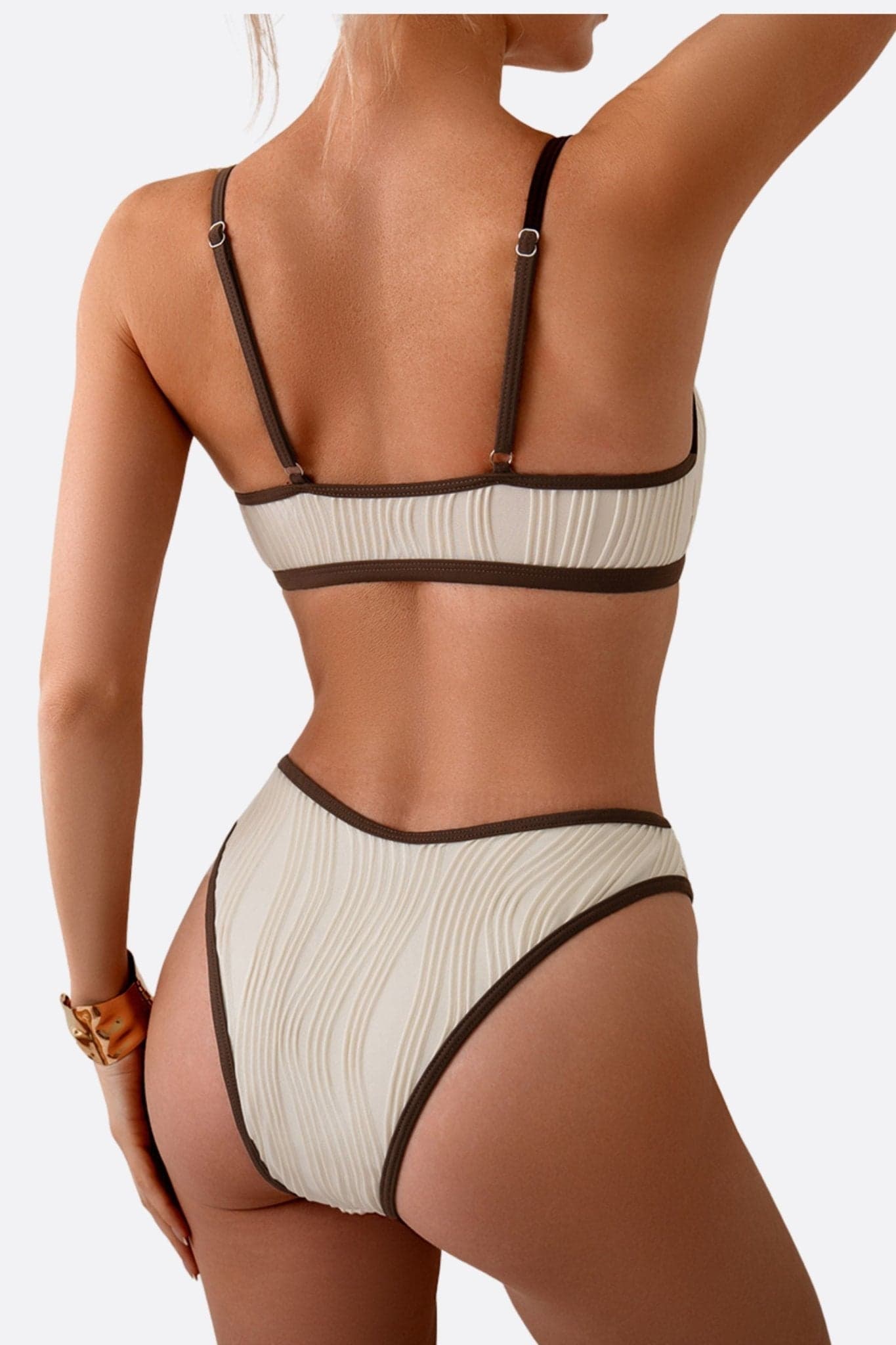 Zweiteiliger Badeanzug in Beige mit braunem Rand, Winkel zeigt wellige Textur, perfekt für sonnige Tage