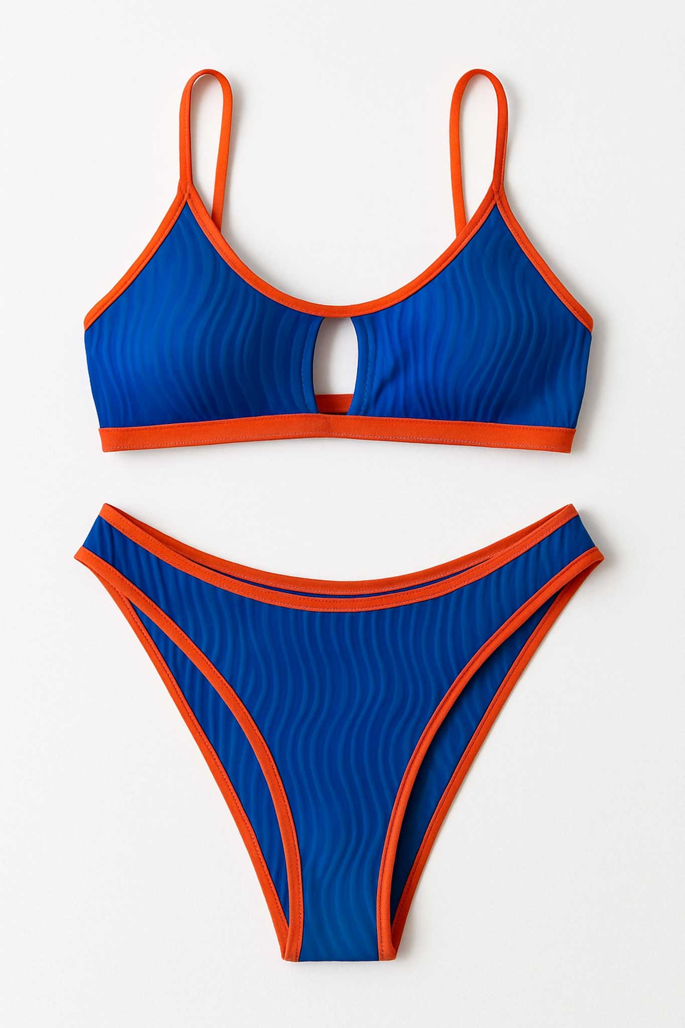 Highlight of the back of the vibrant blue bikini with orange trim, perfect for refined summer evenings.