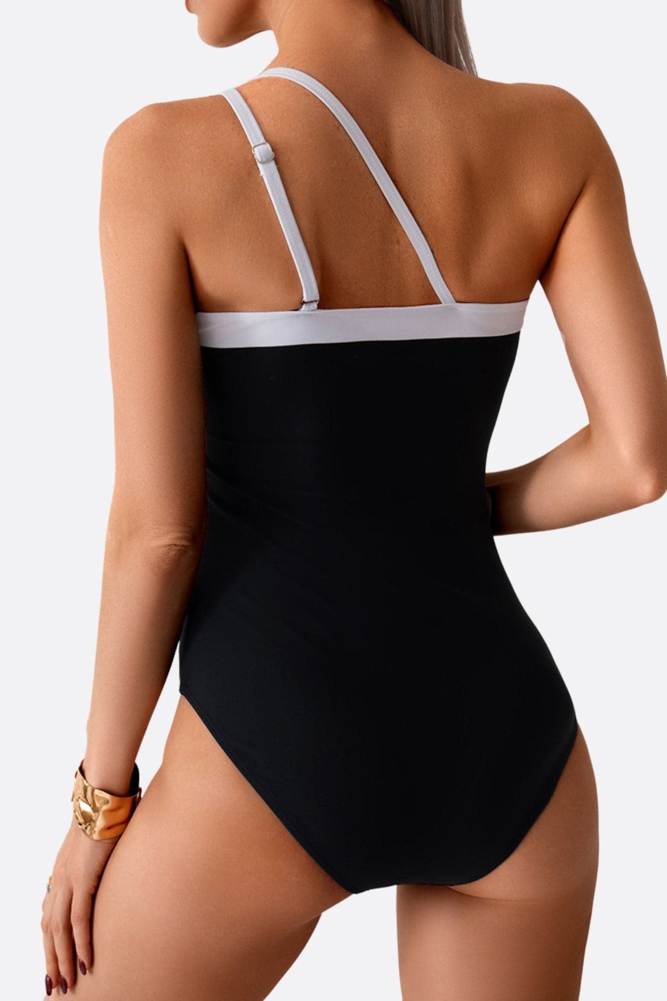 Elegant detail of the black asymmetric one-piece, perfect for a refined look during your seaside holidays.