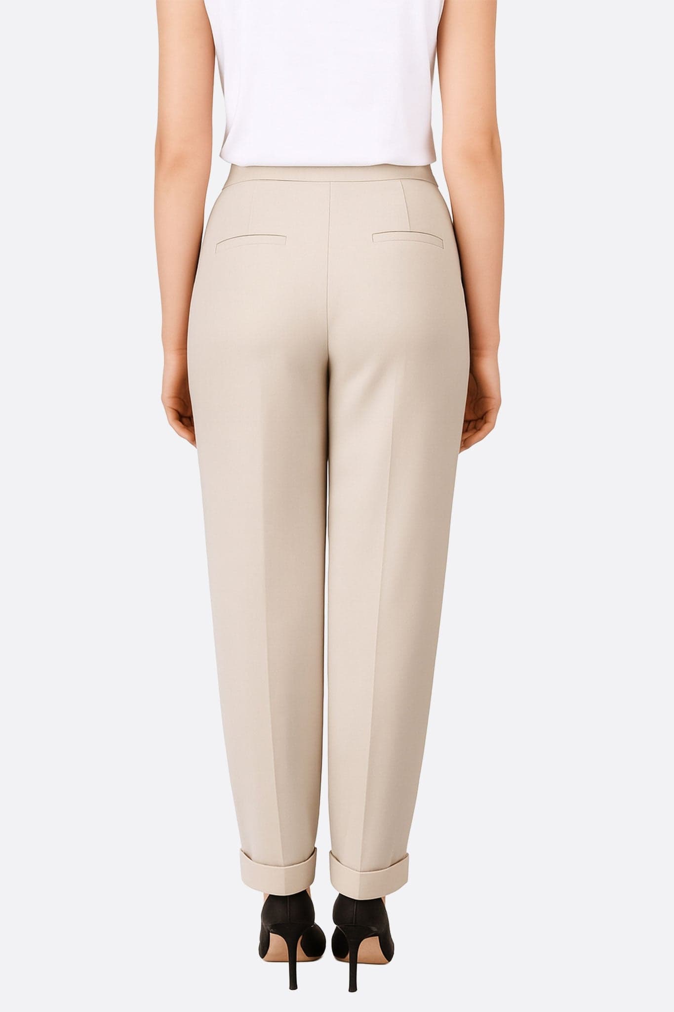 Detail der beigen Hose mit fließendem Schnitt, das ihre weiche und elegante Textur für einen raffinierten Look betont.