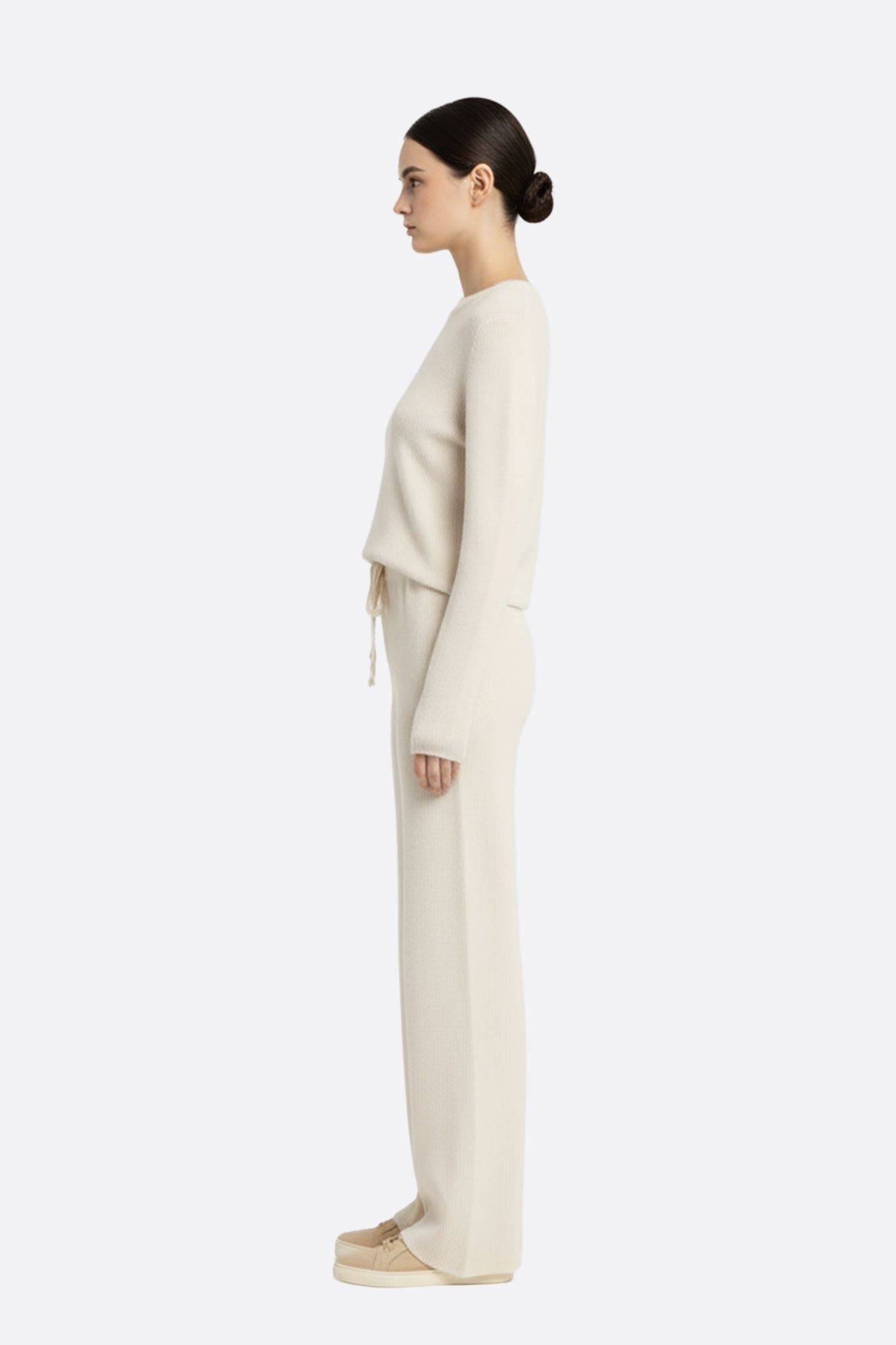 Pantalon en laine blanc à coupe fluide et taille élastique, illustrant une élégance naturelle pour des occasions variées.