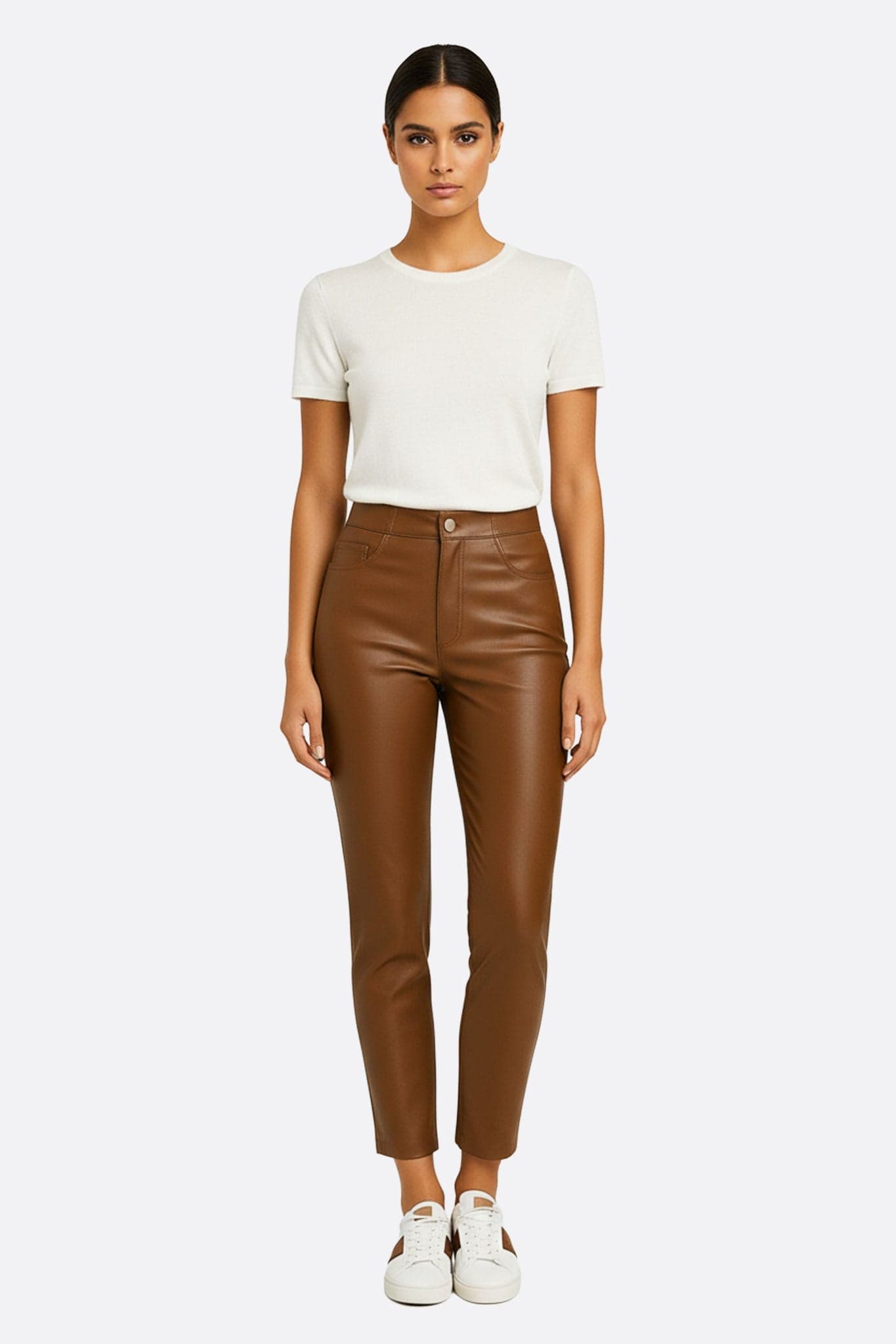Dettaglio raffinato del pantalone in similpelle cammello, che evidenzia il taglio scolpito e l'eleganza per occasioni speciali...