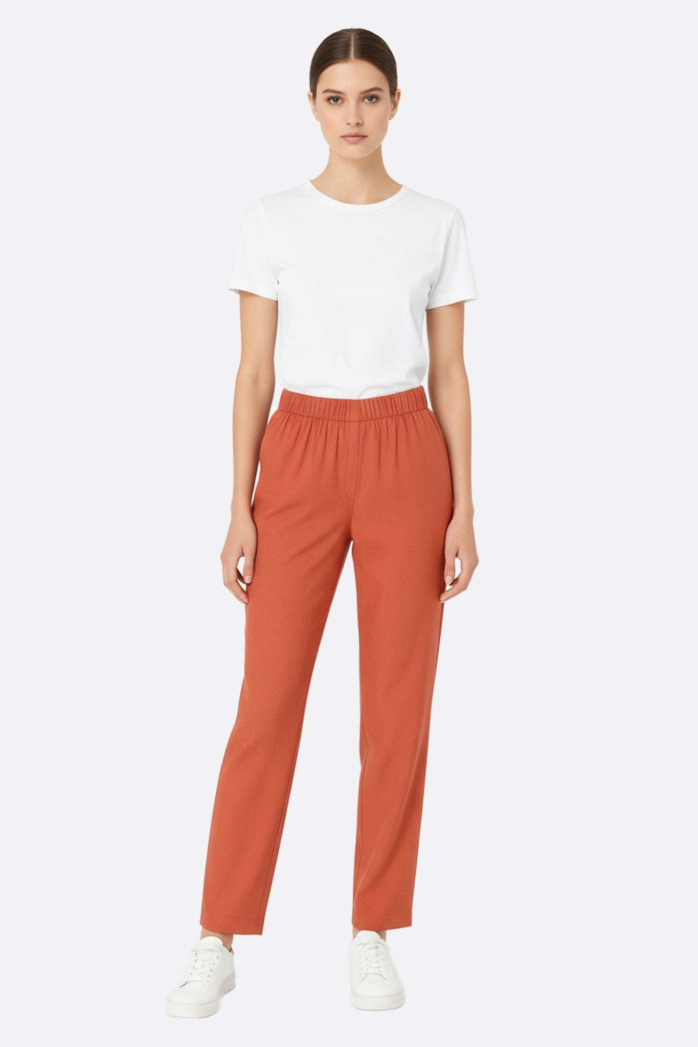 Close-up on the elegant pleat of the terracotta linen trousers, perfect for a casual and chic look on summer days.