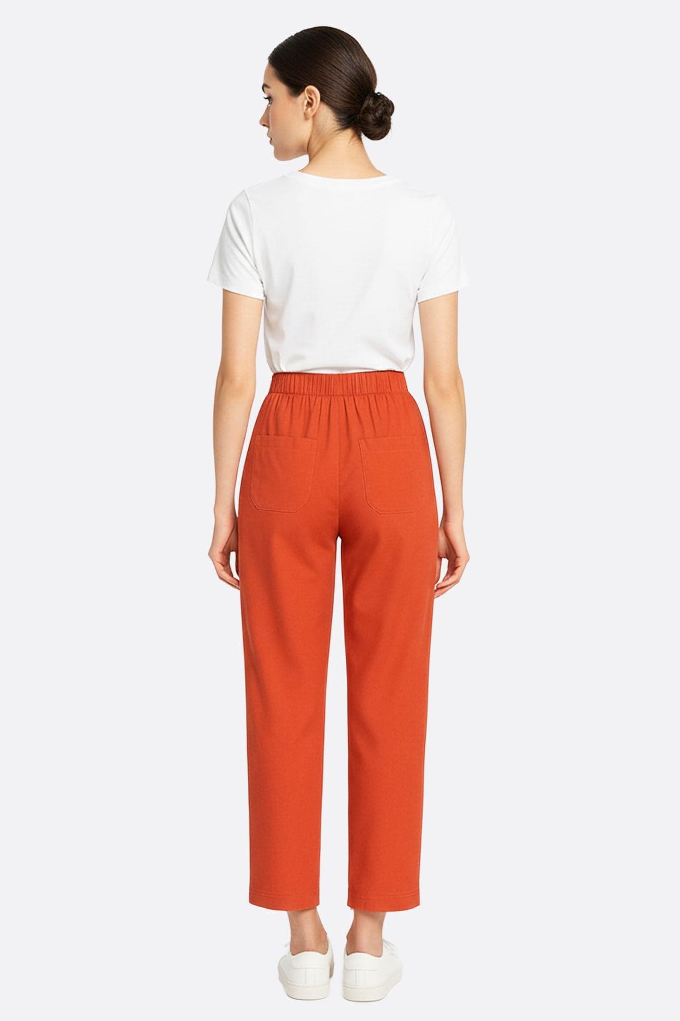 Textura ligera del pantalón fluido de lino terracota, ideal para una salida de verano elegante y casual.