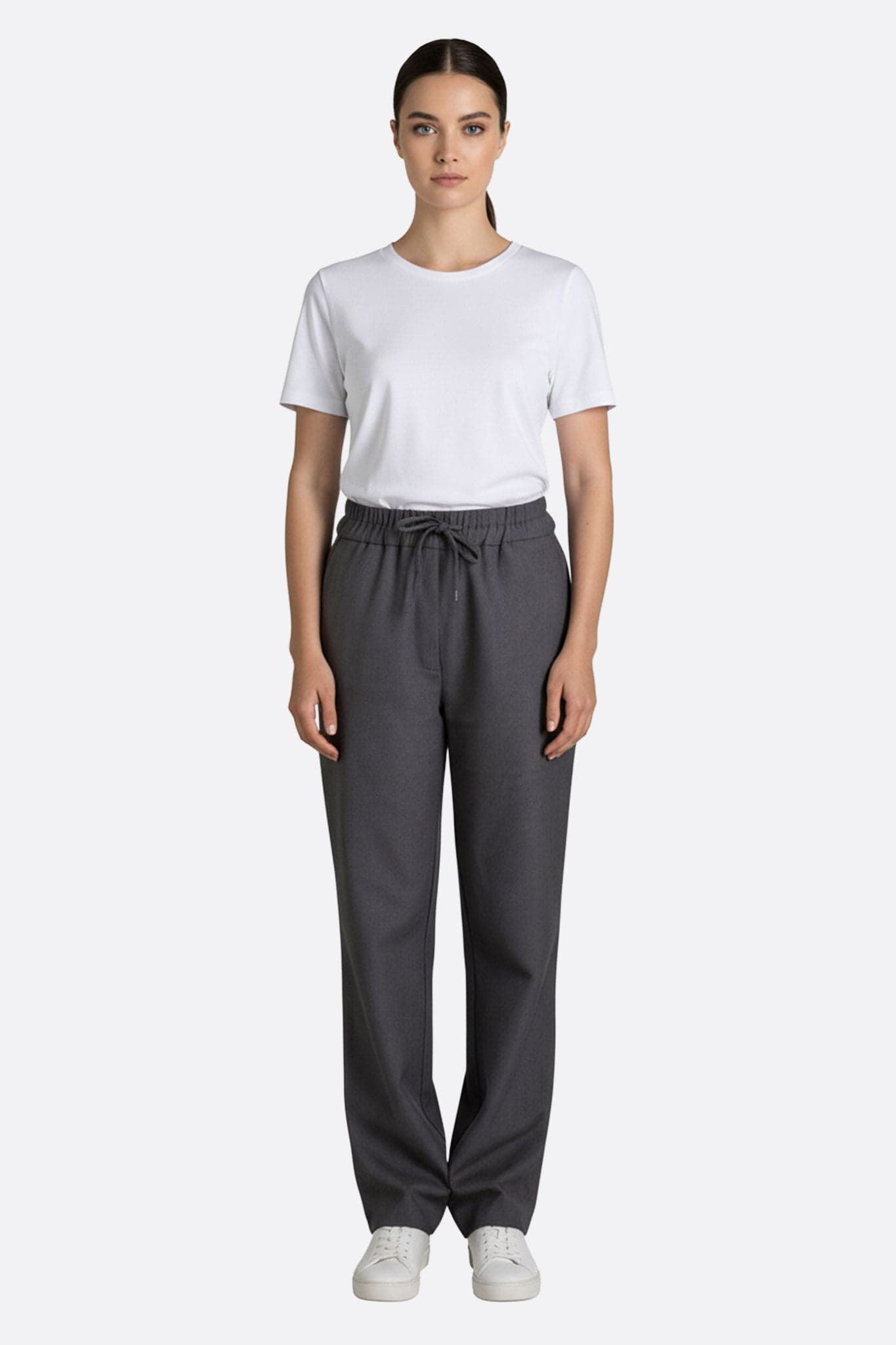 Detail der grauen Hose mit Gummibund, ein modernes Stück, das Komfort und Raffinesse für lässige Momente vereint.