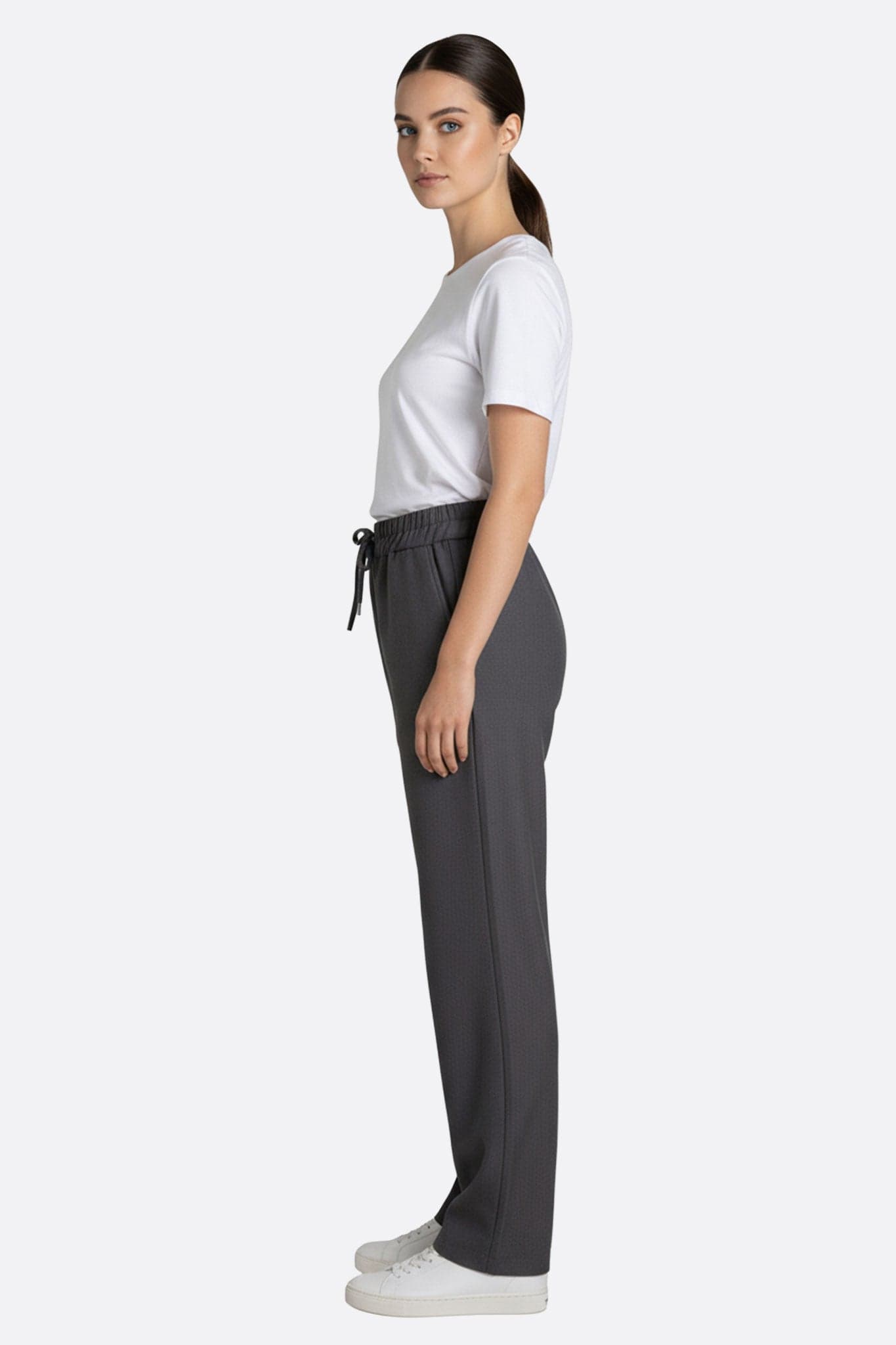 Graue Hose mit Gummibund, 3/4-Ansicht, die ihren stilvollen und lässigen Stil betont, ideal für ein Outfit...
