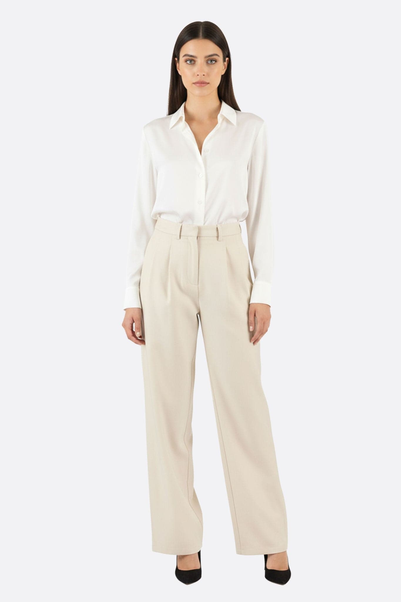 Close-up on the loose beige high-waisted trousers, elegant with their flowing cut for a refined everyday style.
