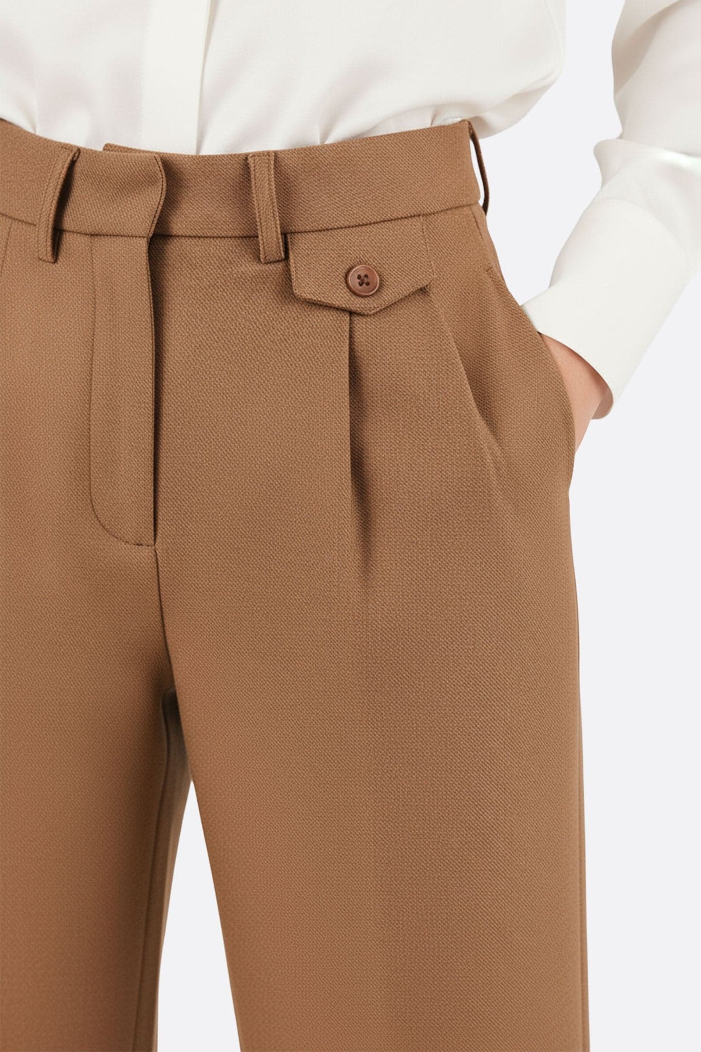 Close-up on the back of flowing wide-leg camel trousers, revealing its soft texture and elegant allure, perfect for...