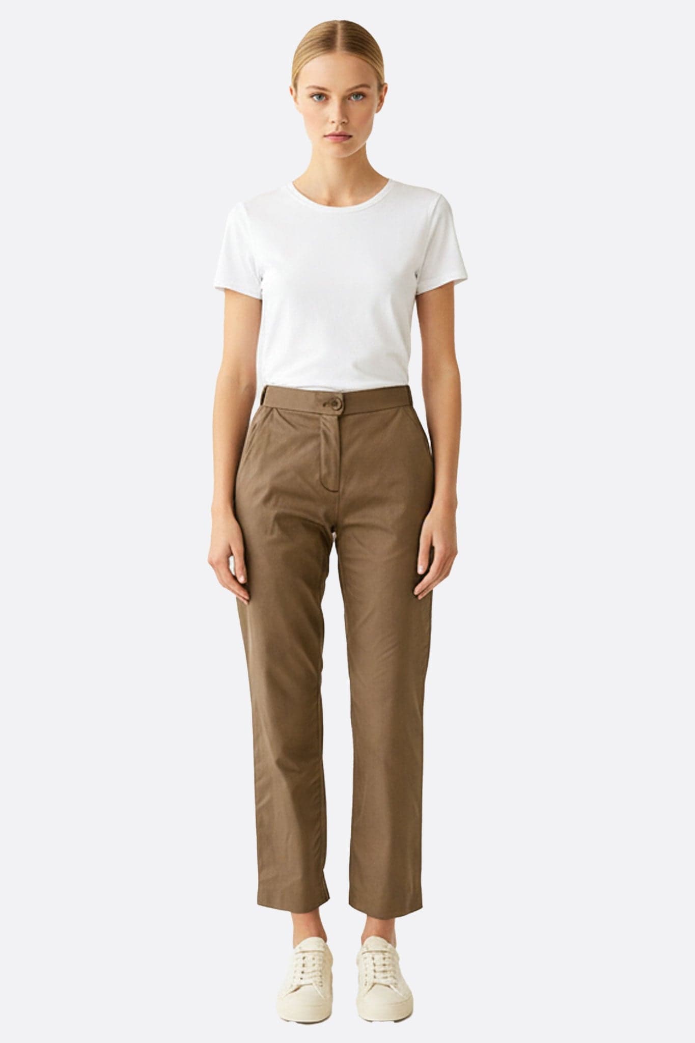 Close-up on the soft texture of the brown high-waisted pants, an elegant choice for a refined look at the office or in the evening.