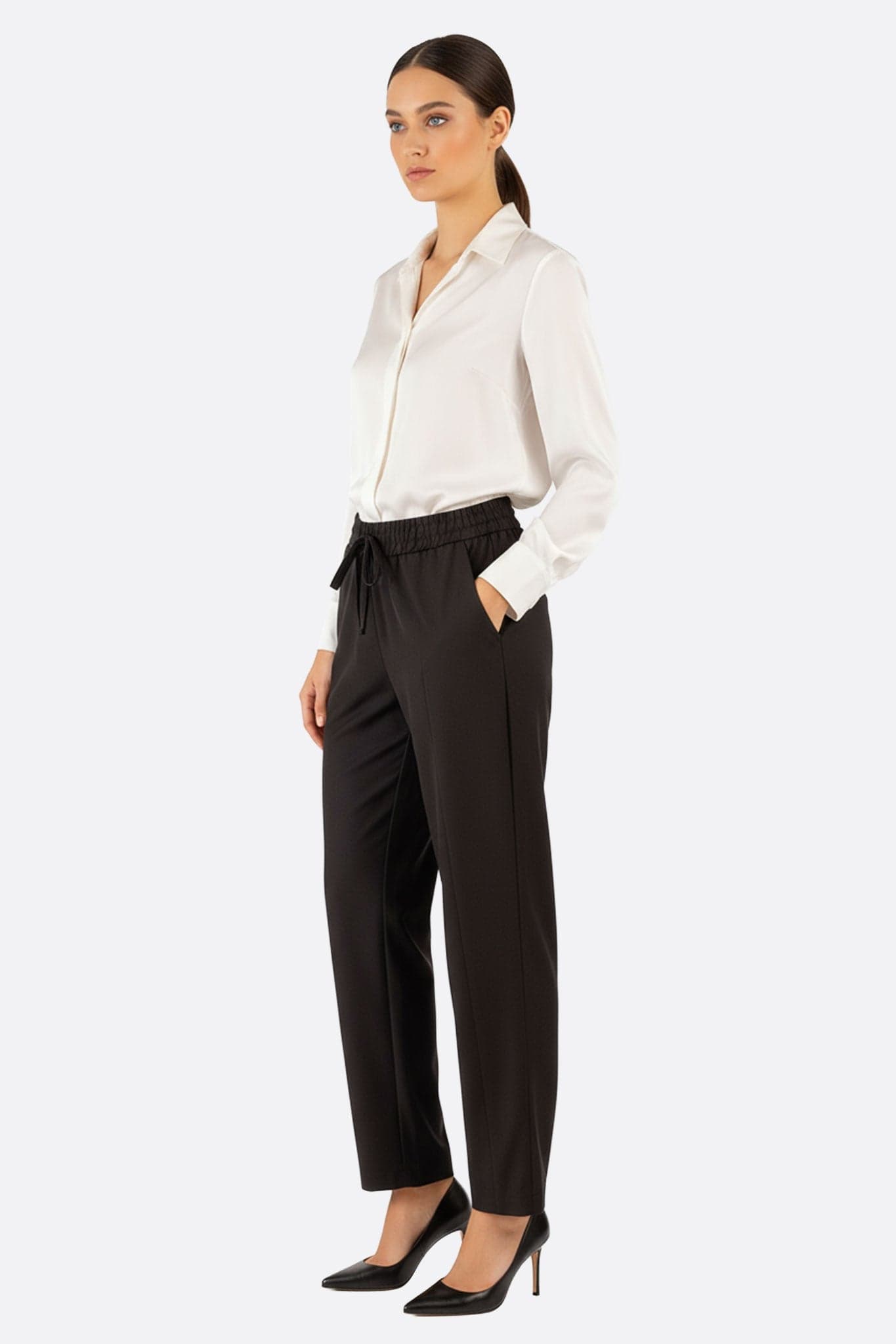 Casual black pants with elastic waist, 3/4 view highlighting its modern cut and light fabric perfect for...