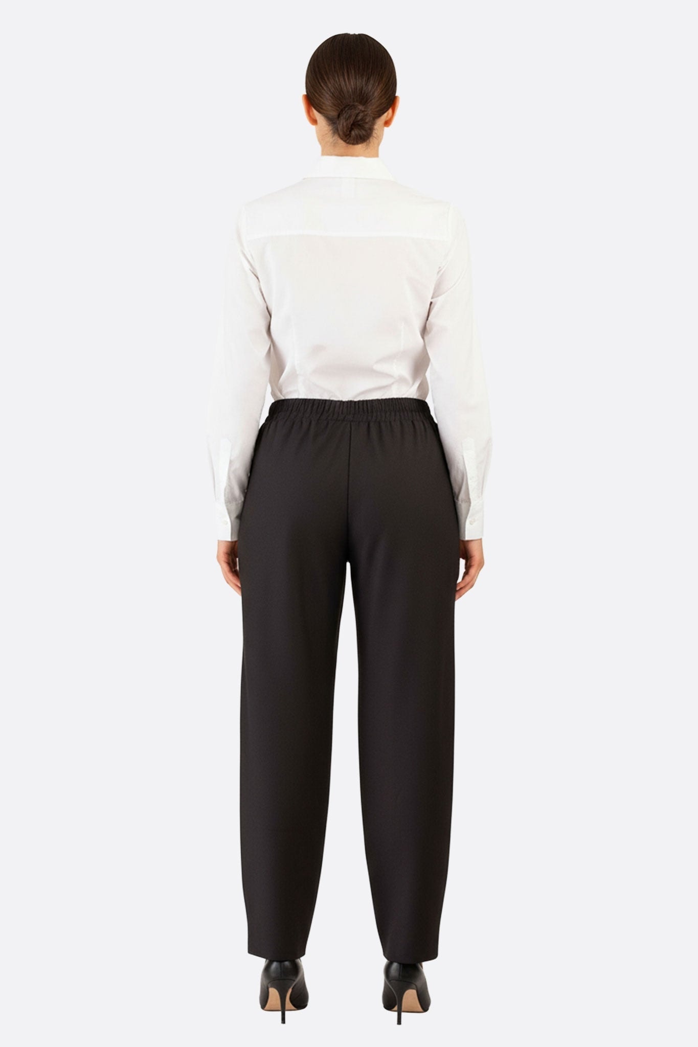 Dettaglio raffinato della parte posteriore del pantalone nero con vita elastica, che ne evidenzia la consistenza morbida e lo stile casual.