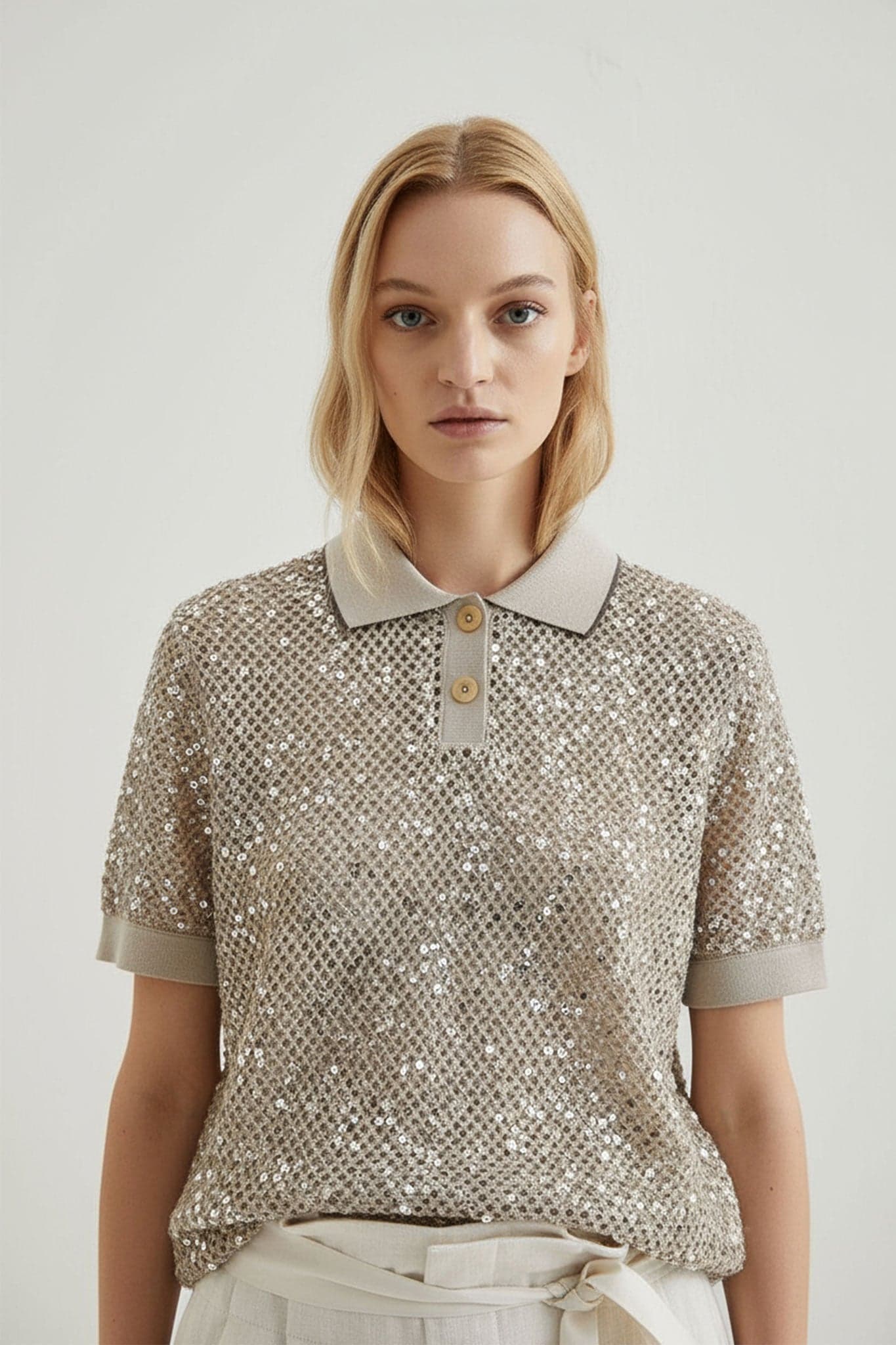 Refined detail of a sand beige openwork knit polo, adorned with tone-on-tone sequins, ideal for a chic summer look.