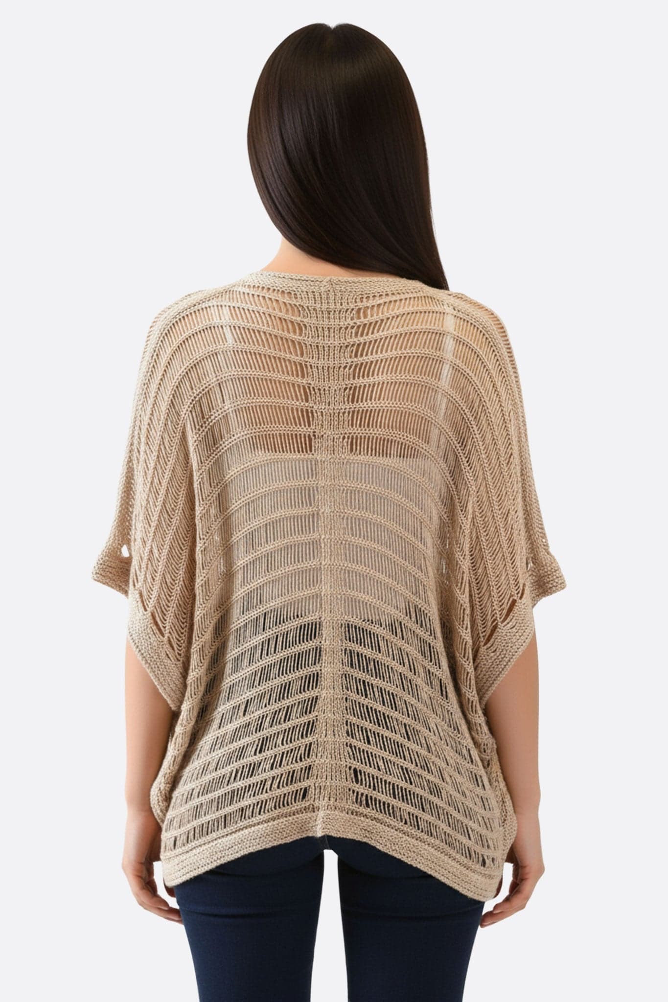 Feine Details des beigen Ponchos in Lochmuster im Boho-Stil, ideal für einen Sommerabend oder ein lässiges Outfit.