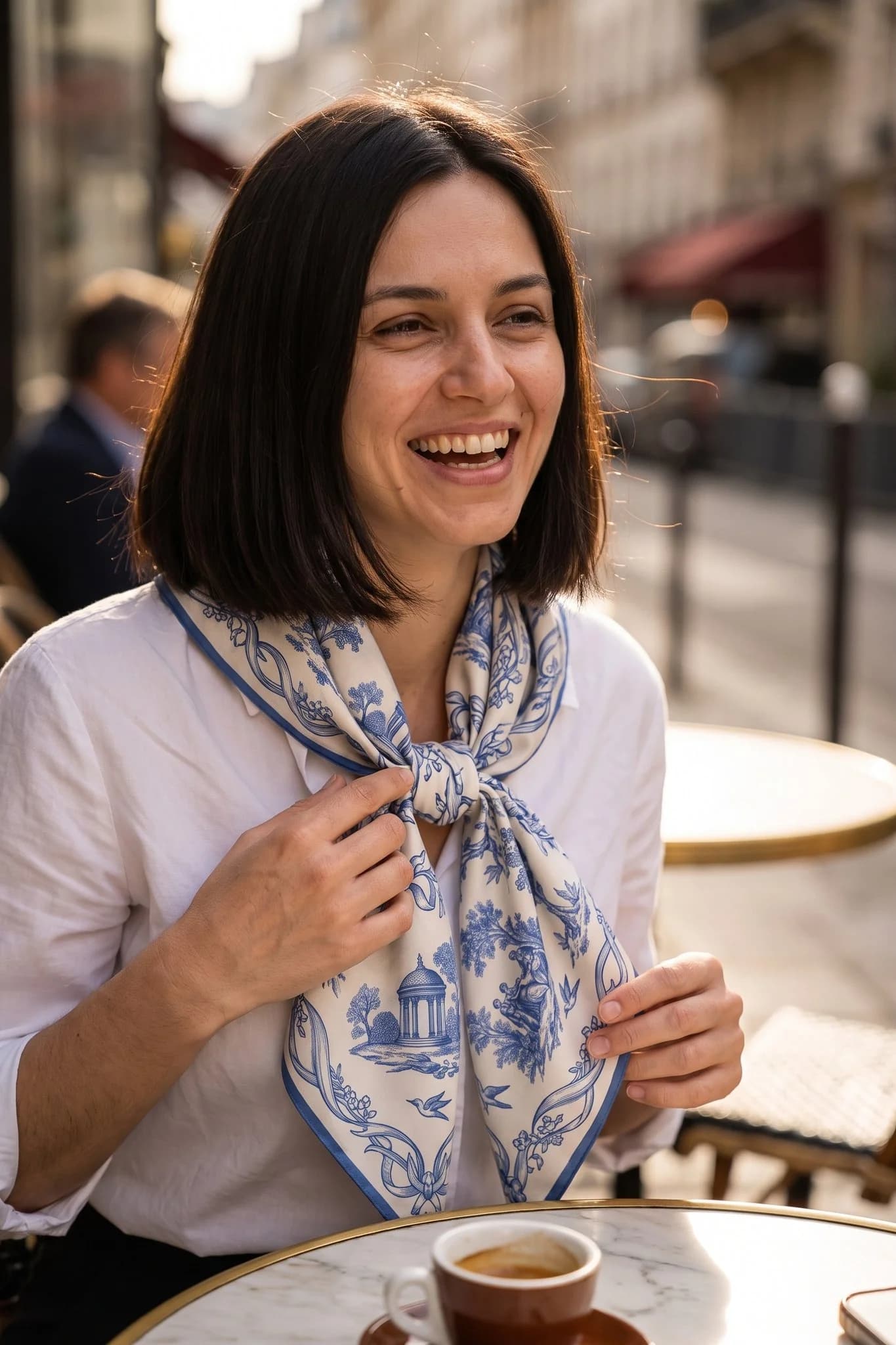 Donna che indossa il foulard di seta Toile de rêverie annodato in una strada di Parigi