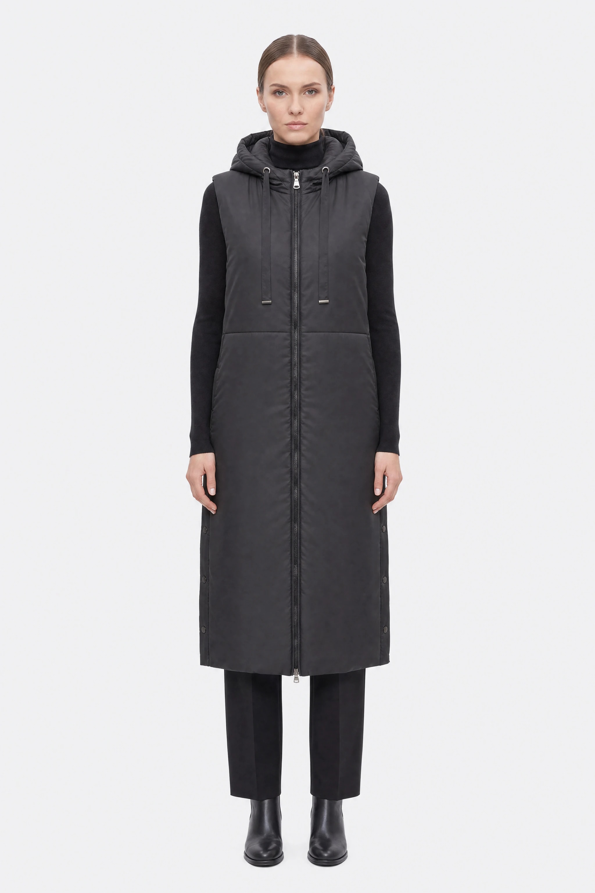 Schwarze, lange, ärmellose Daunenjacke mit Kapuze, getragen, Vorderansicht