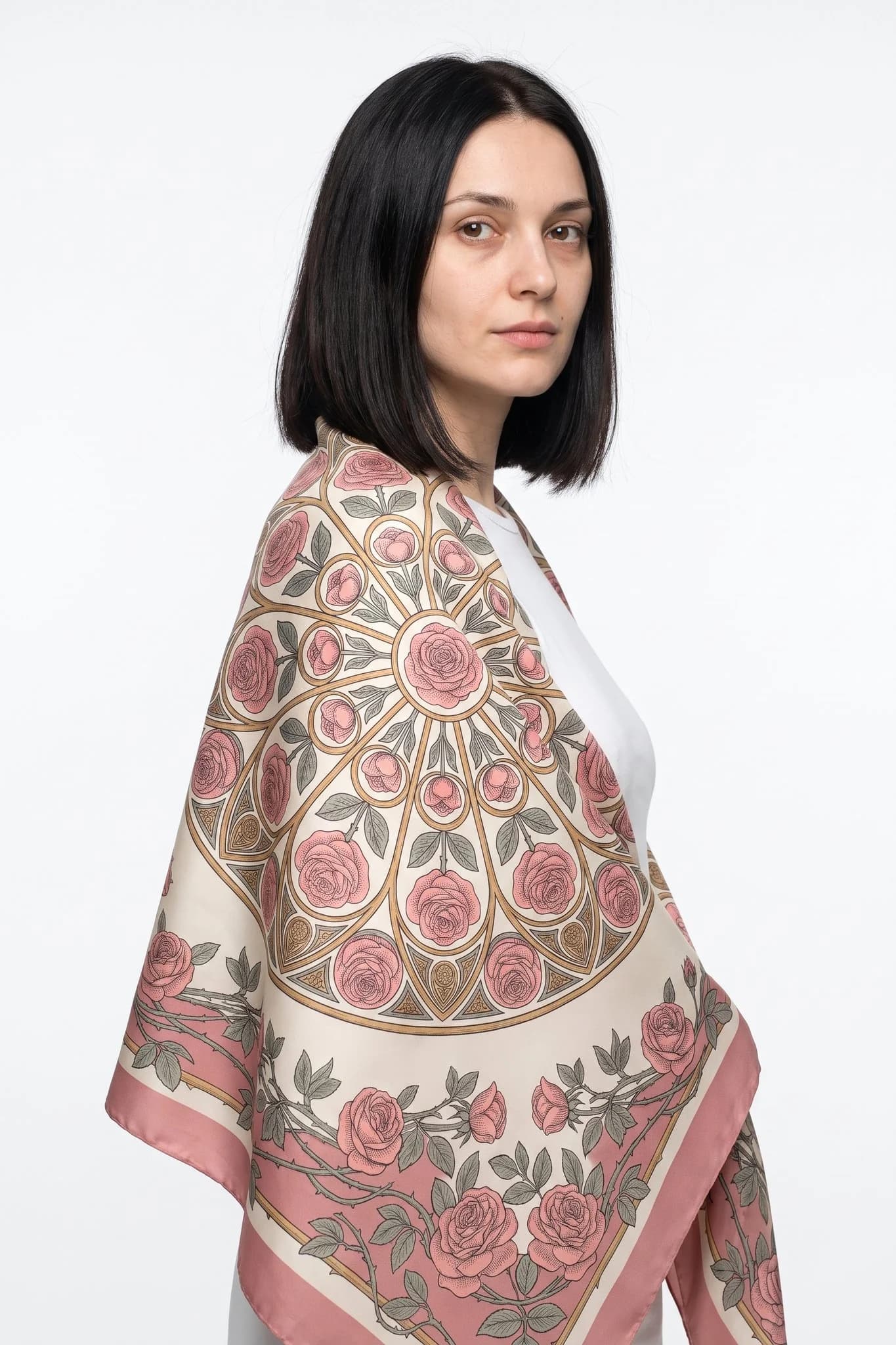 Grande foulard di seta 110 Cathédrale de roses indossato come stola sulle spalle di una donna, vista in studio