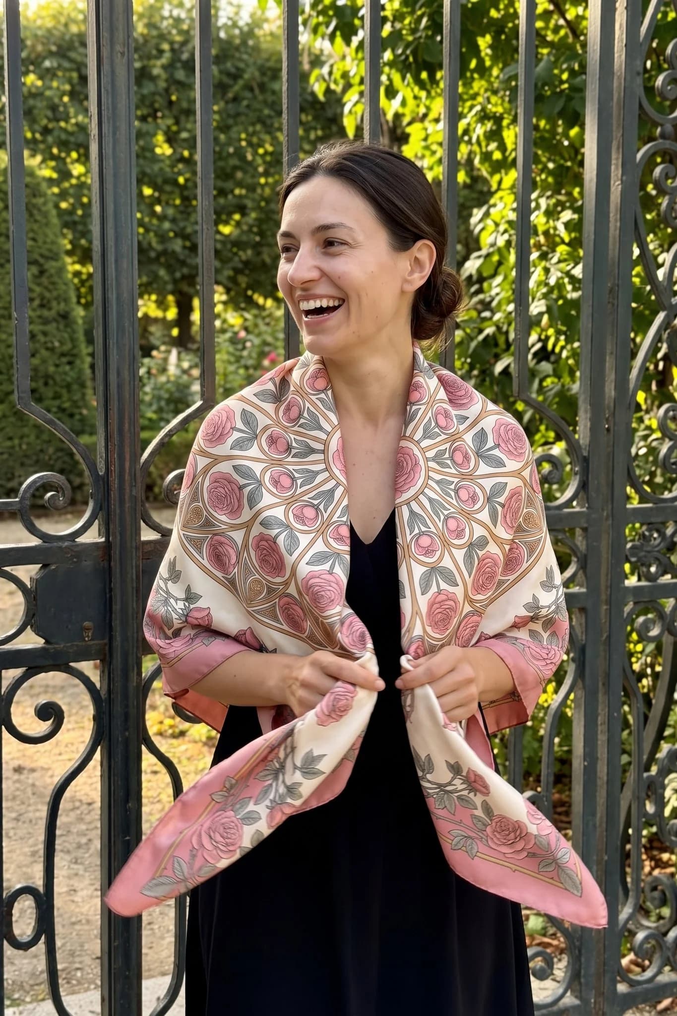 Donna che indossa il foulard di seta Cathédrale de roses come scialle in una strada di Parigi