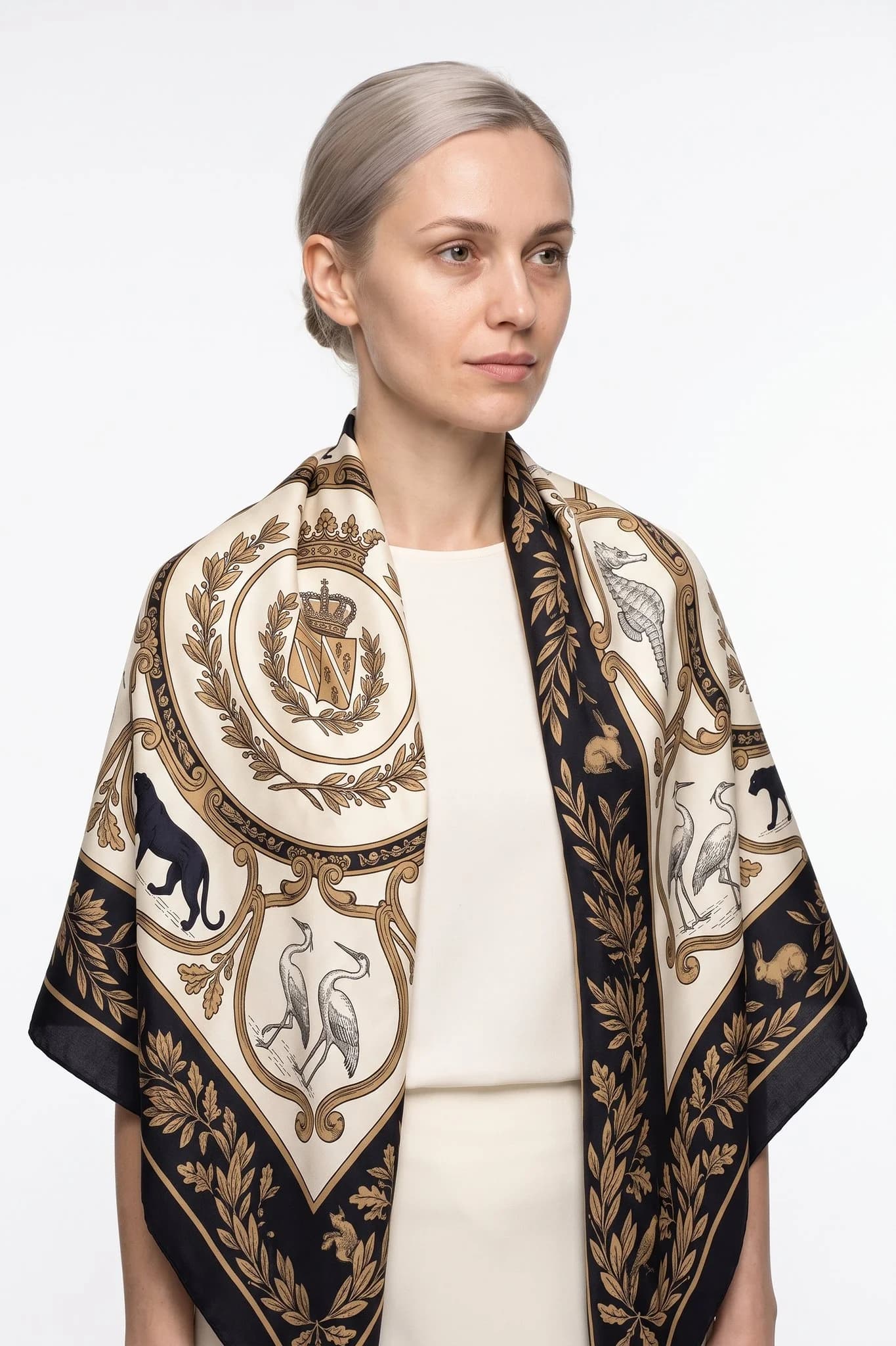 Grande foulard di seta 110 Ménagerie royale indossato come stola sulle spalle di una donna, vista in studio