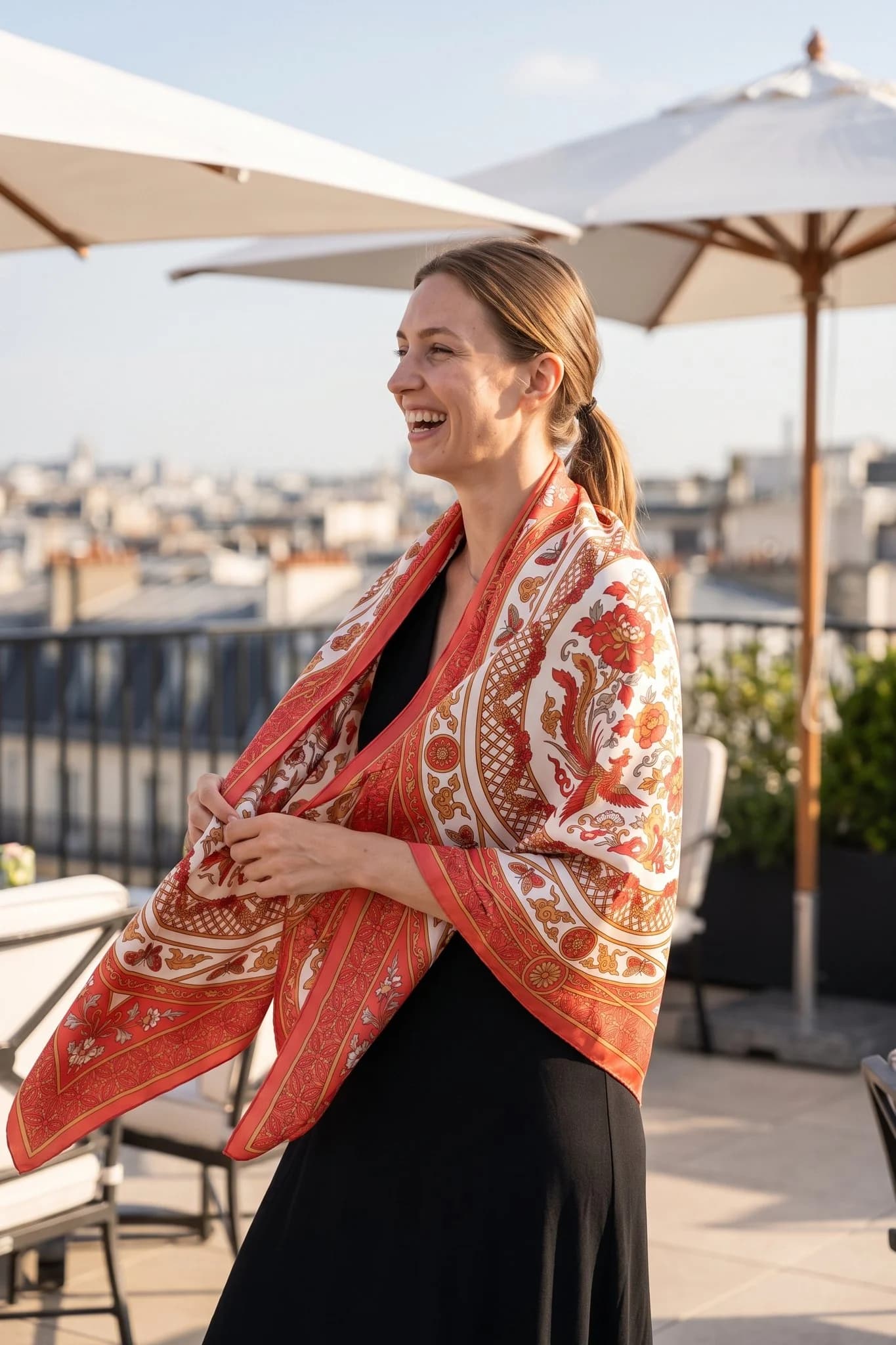 Frau trägt das Seidentuch Porcelaine corail als Schal auf einer Straße in Paris