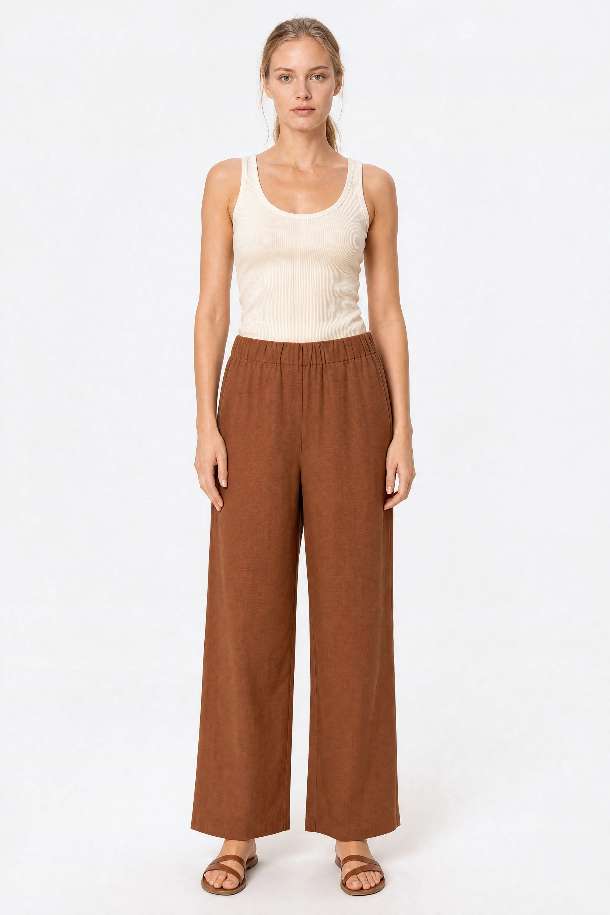 Wide brown linen Misciano pants worn front-facing with a cream tank top, elastic waistband and flat front with no patch pockets