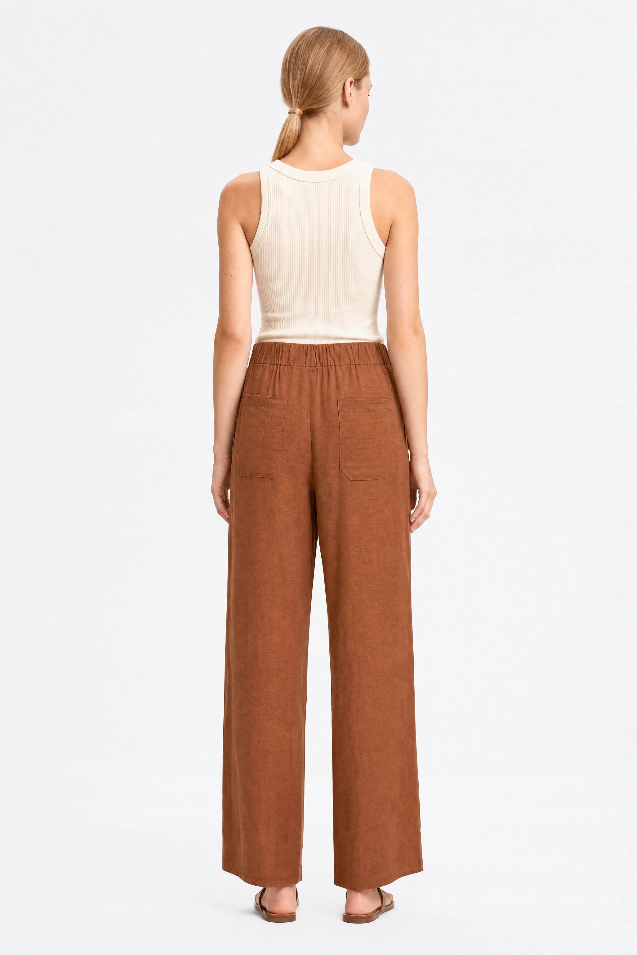 Back of the wide brown linen pants, gathered elastic waistband and two patch pockets at the back