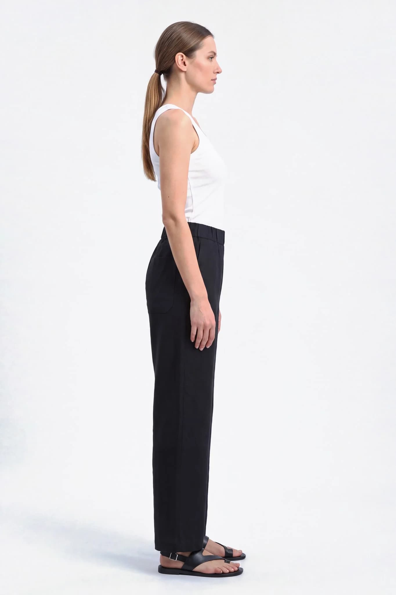 Pantalon large en lin noir vu de profil, tombé droit et ample