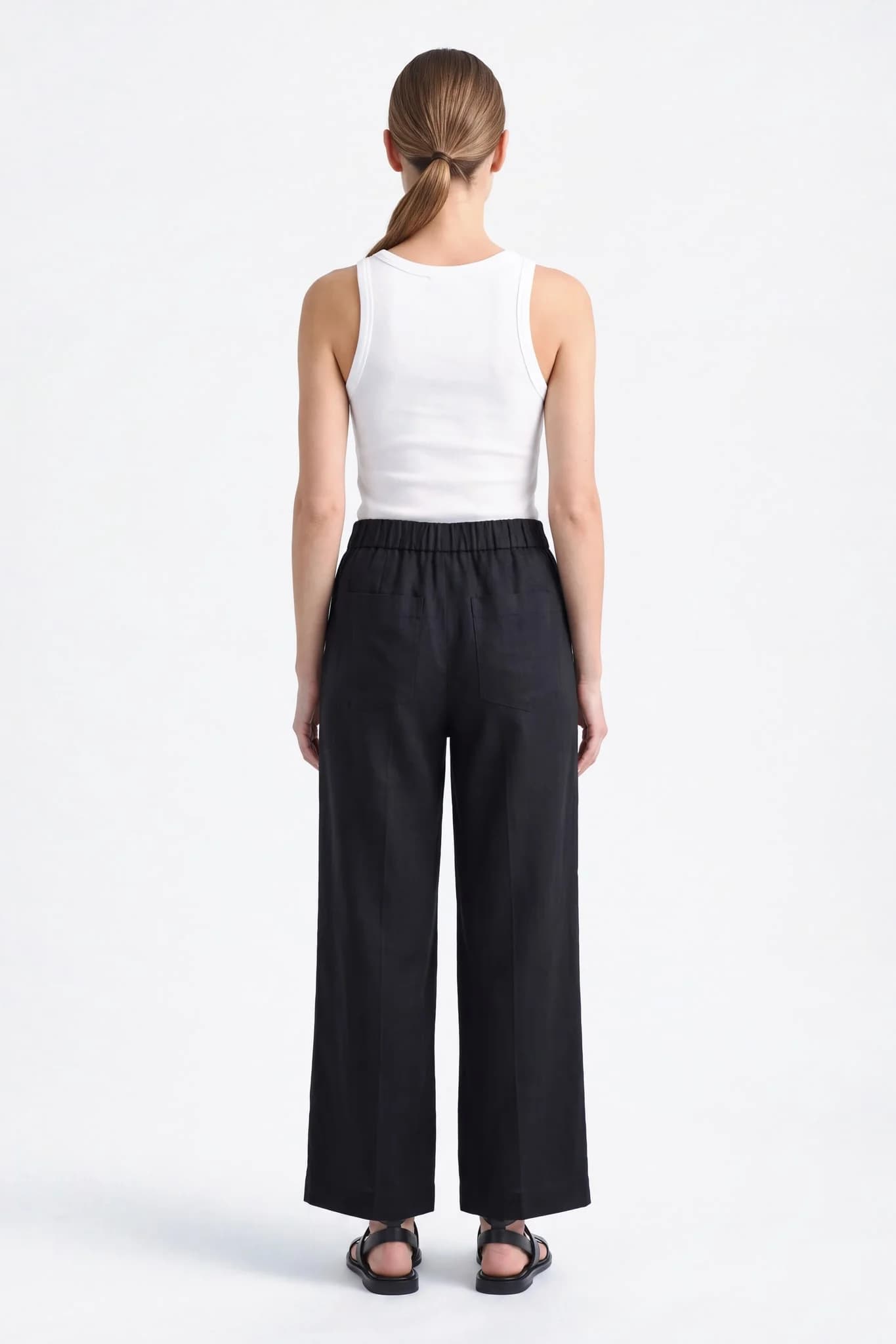 Dos du pantalon large en lin noir, ceinture élastique et deux poches plaquées