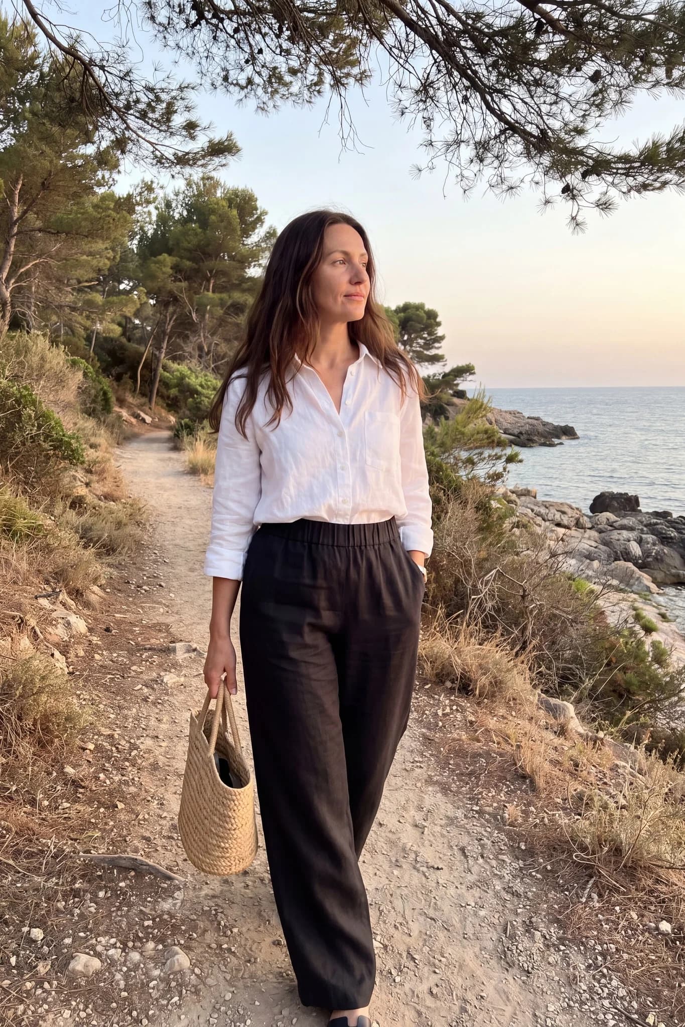 Pantalon large en lin noir porté sur un sentier côtier en fin de journée