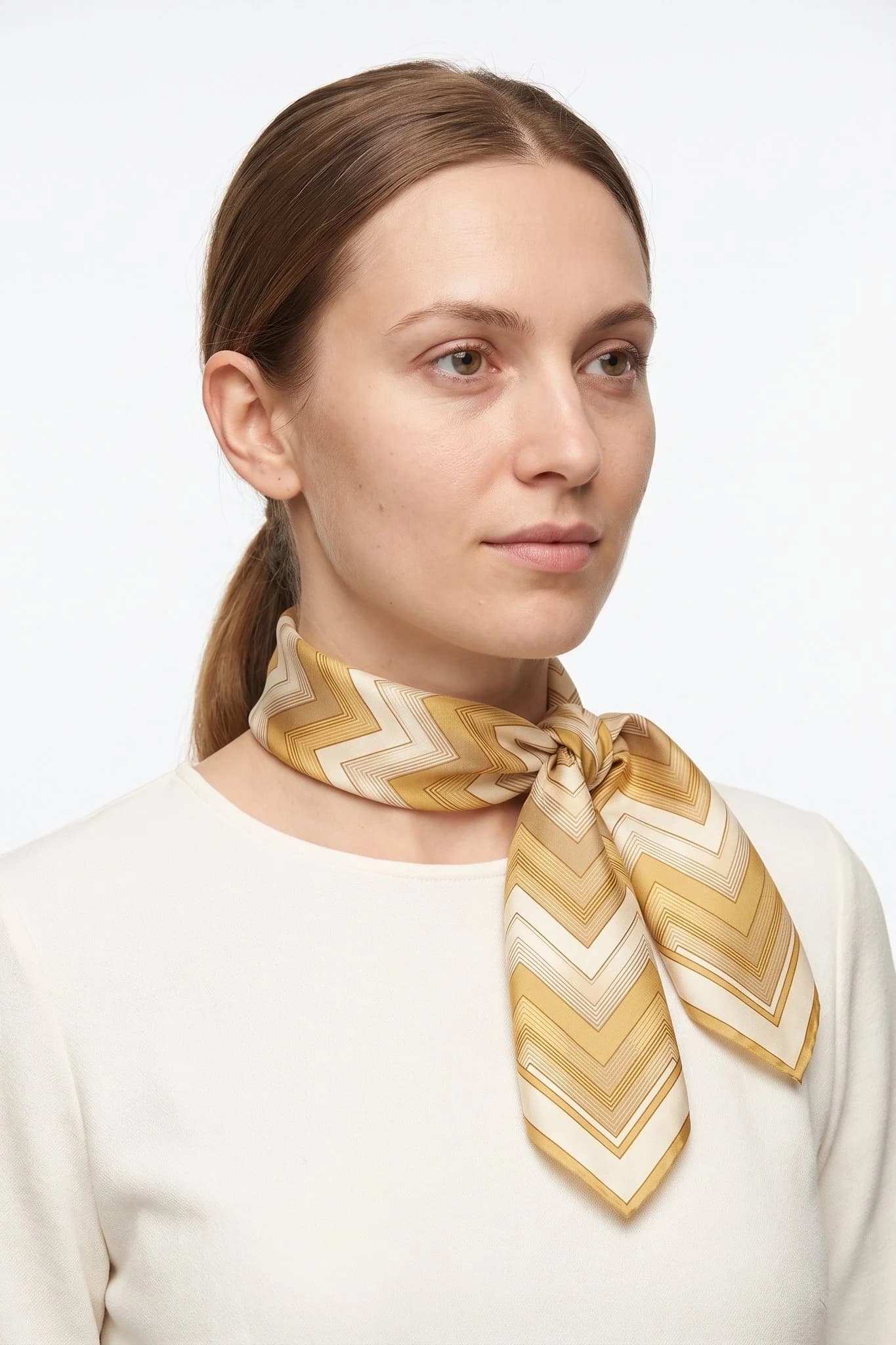 Kleines Seidentuch 50 Chevrons d'or als Halstuch einer Frau gebunden, Studioaufnahme