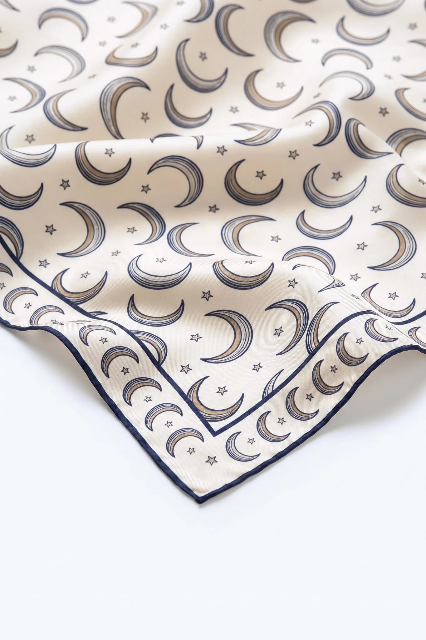Close-up on the folds of the Croissants de lune silk scarf, silk twill and hand-rolled edge