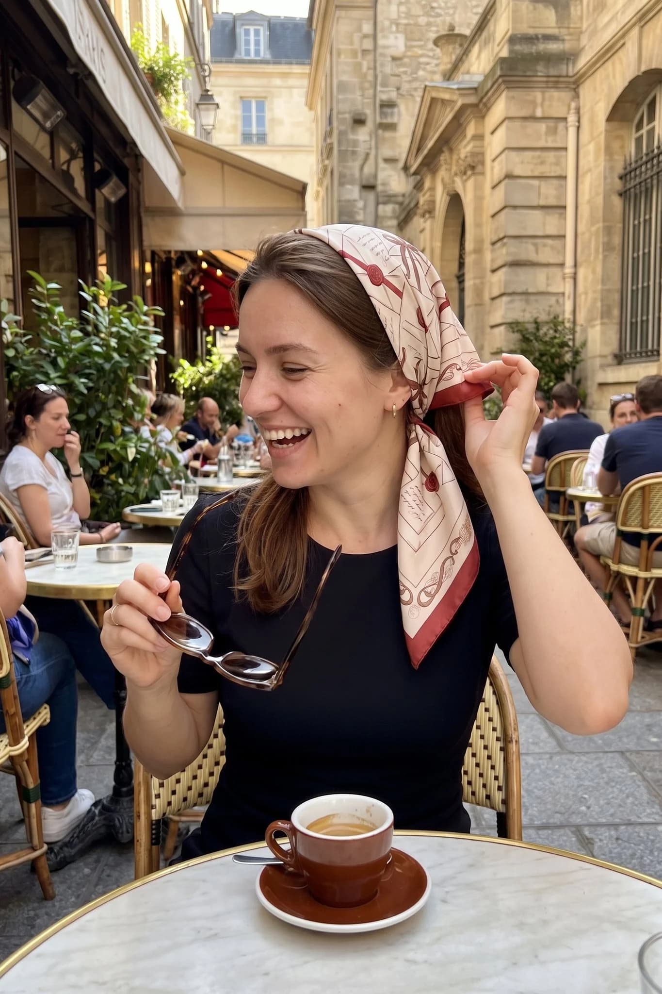 Woman wearing the Love Letters silk scarf as a bandana in her hair on a Paris street